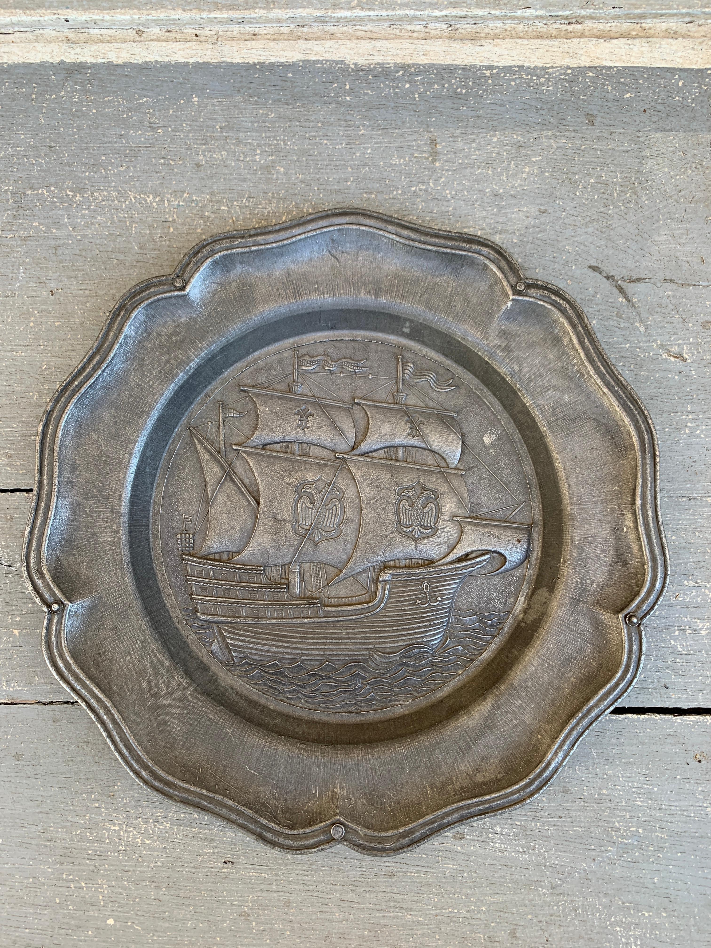 Schöner Wandteller aus Zinn mit einem Segelschiff auf Vollmast und heraldischen Doppeladlern an den Masten

Deutschland, Mitte des 20. Jahrhunderts

Maße: 8,75 