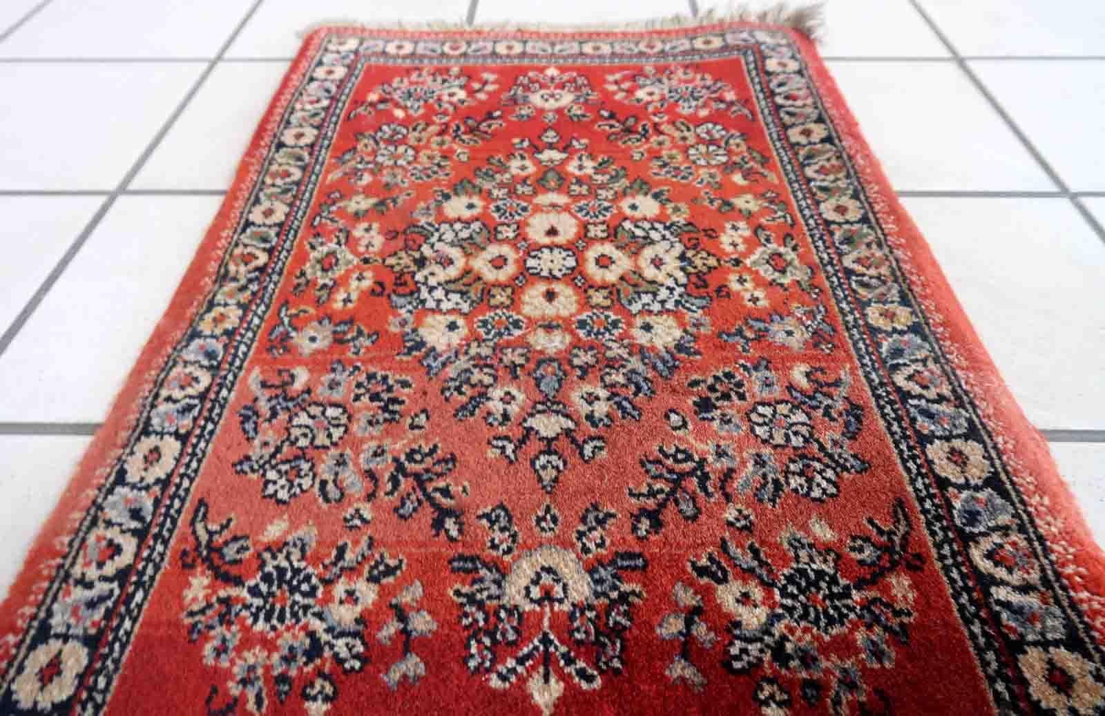 Vintage red German rug in traditional Persian Sarouk design. The rug has been made in the end of 20th century, it is in original good condition. The rug is machine made.

-condition: original good,

-circa: 1970s,

-size: 1.3' x 2' (42cm x