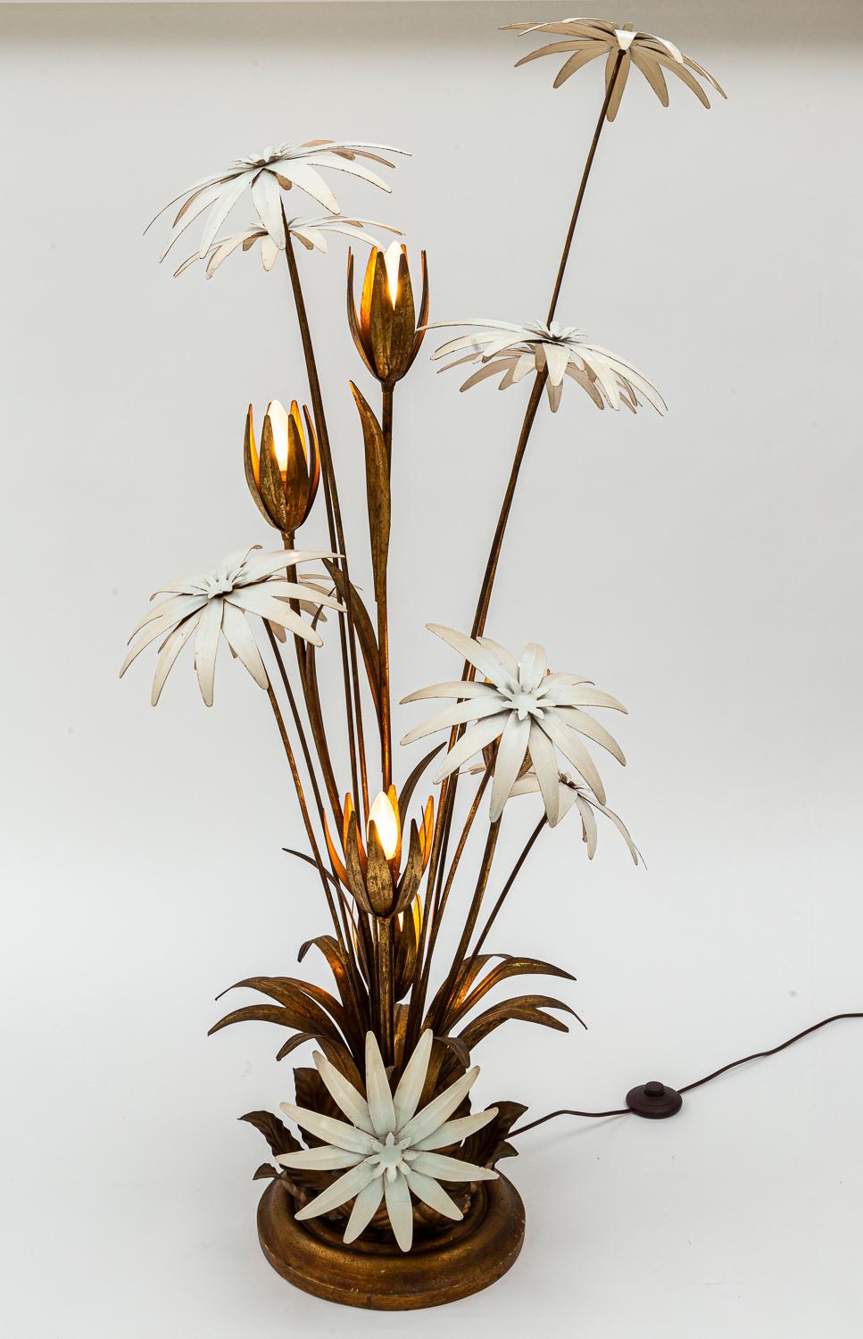 Ce lampadaire sculptural très charmant et décoratif présente cinq fleurs de lotus illuminées en cascade, peintes en doré antique, entourées de neuf palmiers arqués émaillés de crème, de différentes hauteurs.

Origine : Allemagne par le