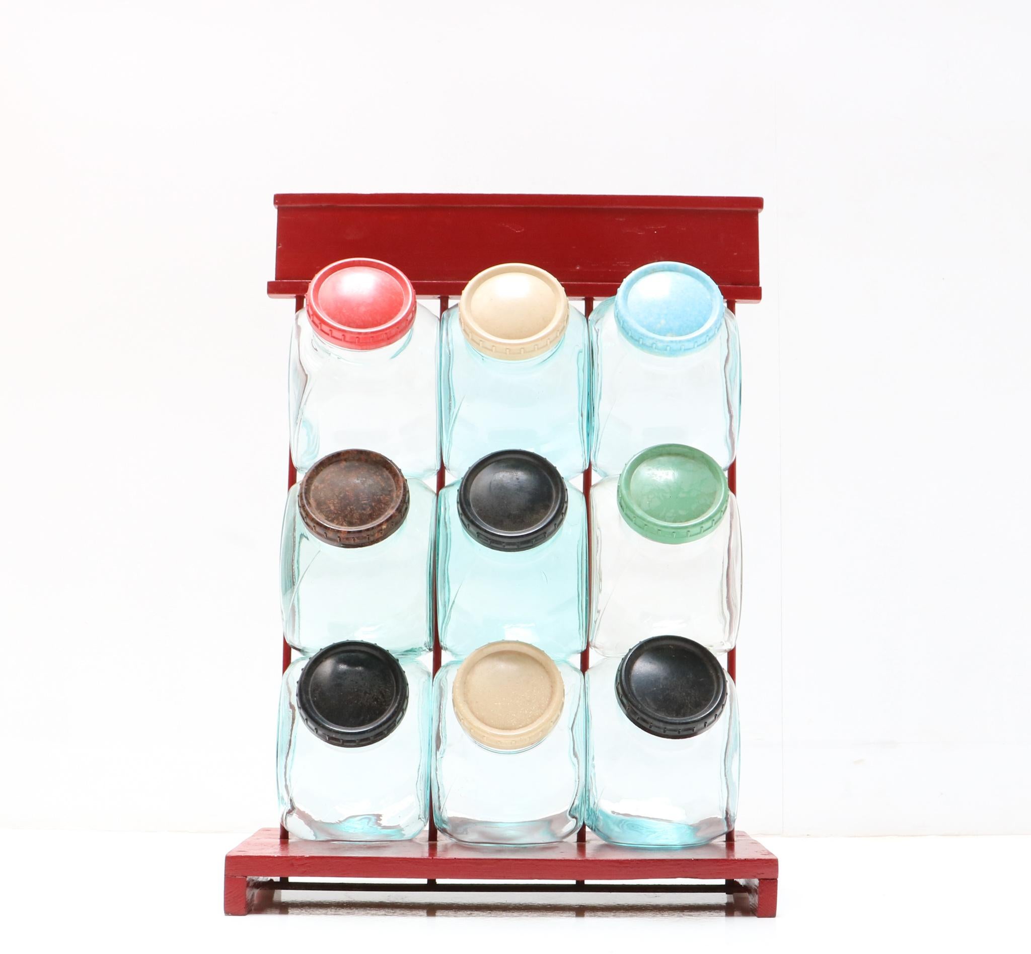 Stunning and rare Vintage shop display stand with nine jars.
Striking German design from the 1950s.
Antique red painted wood and metal frame with nine original
hand-blown glass jars with multi-colored original bakelite lids.
This wonderful