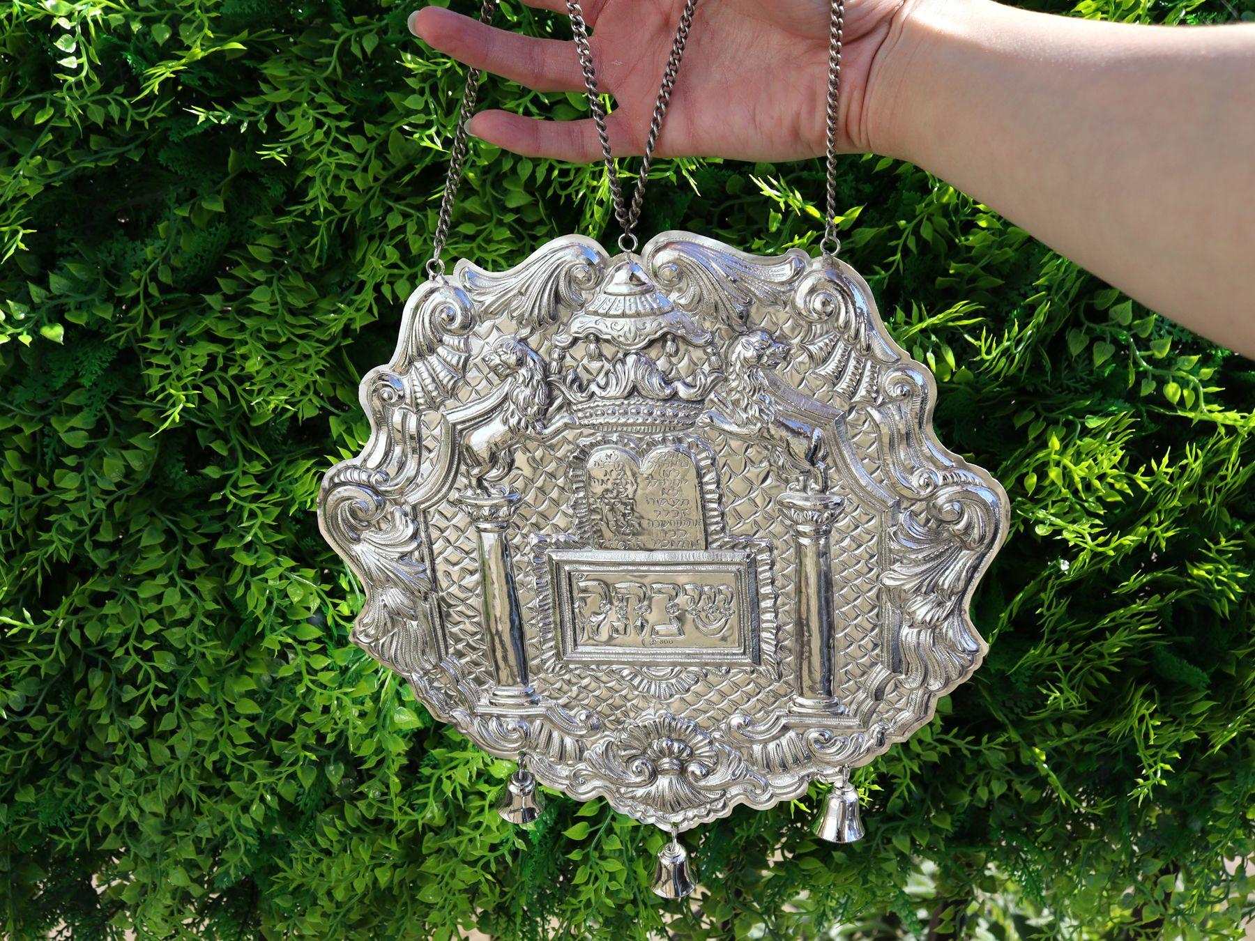 Un raffinato e imponente pettorale della Torah in argento tedesco d'epoca; un'aggiunta alla nostra collezione di argenteria giudaica.

Questo eccezionale pettorale Torah d'argento standard tedesco 800 vintage ha una forma circolare.

La superficie