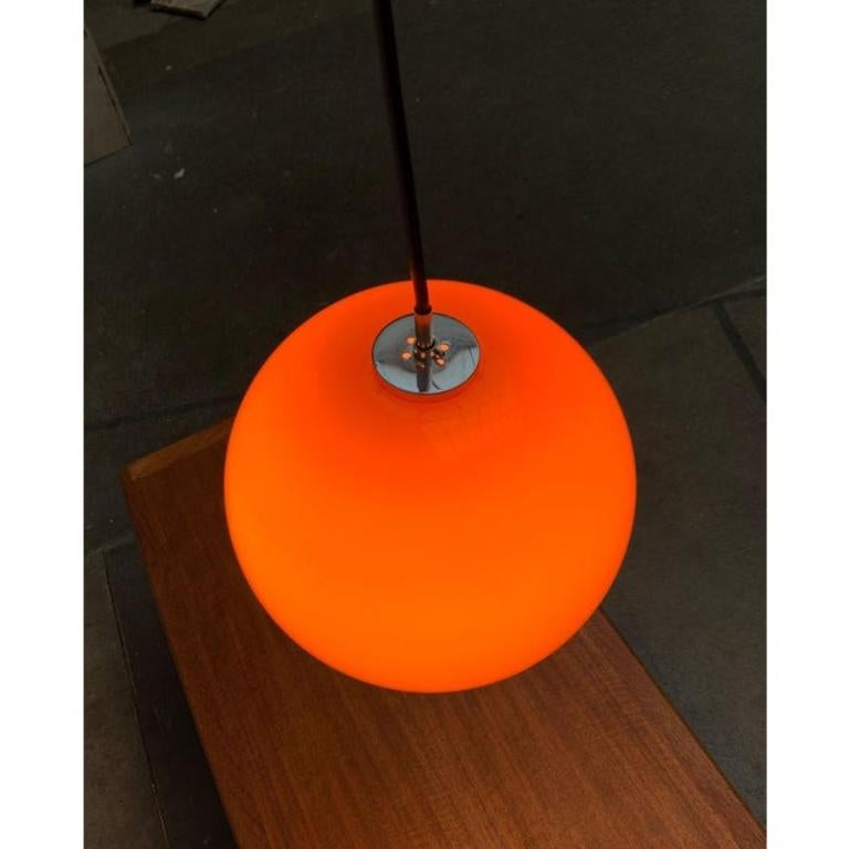 Lampada a sospensione in vetro del rinomato produttore Peill & Putzler.

Un design elegante. Una semplice sfera con un vetro arancione sovrapposto forma il corpo dell'apparecchio e funge da diffusore. Ha un'ampia apertura e lascia la luce diretta