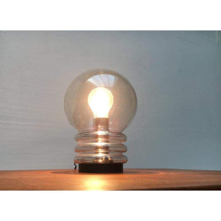 Lampe de table en verre à ampoule de la célèbre maison Glashütte Limburg.

Le corps de la lampe est en verre transparent et repose sur un socle en plastique. La partie supérieure du corps en verre est conçue comme une sphère. La partie inférieure