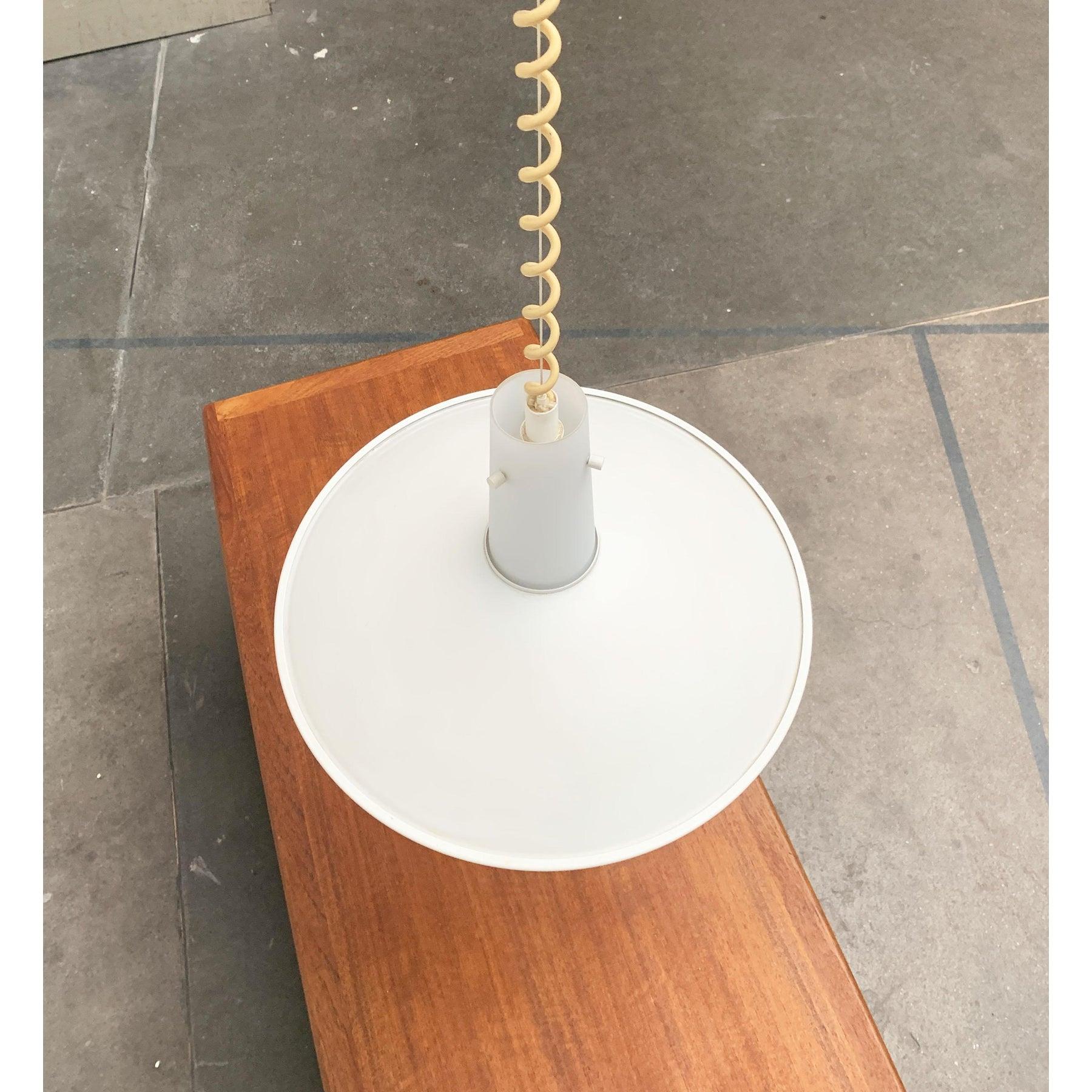Large pendant light from the prestigious home Glashütte Limburg.

The core of the luminaire consists of a glass cylinder that expands down. On the central glass is a flat metal screen. The screen has an imposing size of 45 cm in diameter and is