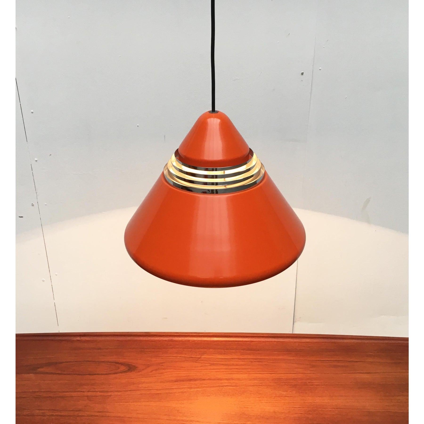 Rara pendola della nota casa produttrice Staff Leuchten su disegno di Alfred Kalthoff degli anni '70.

La tonalità mostra una semplice forma a cono, che si dissolve in lamelle nel terzo superiore. Il colore di base è il rosso-arancio. In contrasto