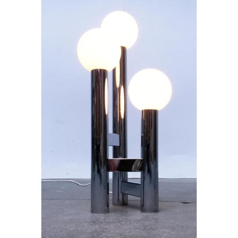 Lampe de table ou lampadaire Space AGE en chrome et verre.

Une forme simple mais imposante. La lampe se compose de cylindres chromés de différentes hauteurs, reliés par des toiles dans un triangle. Au sommet de chacune d'entre elles se trouve une