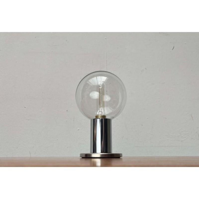 An impressive space age table lamp from staff, based on a design by japanese designer motoko ishii from the 1970s.

this design impresses with its reflective surface and striking diffuser sphere. A cylindrical shaft sits on a round base plate. At