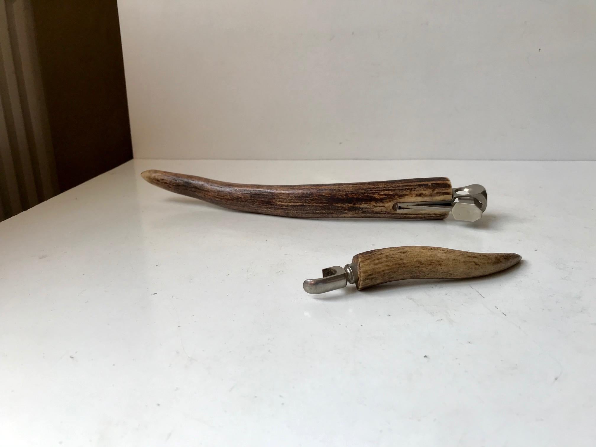 Bar set consisting of a large stag handled cigar cutter (L: 29 cm) and a matching small bottle opener (14 cm). Both of them are continental and presumably made in Germany circa 1960-70. The cigar cutter features a mechanism from Sollingen.