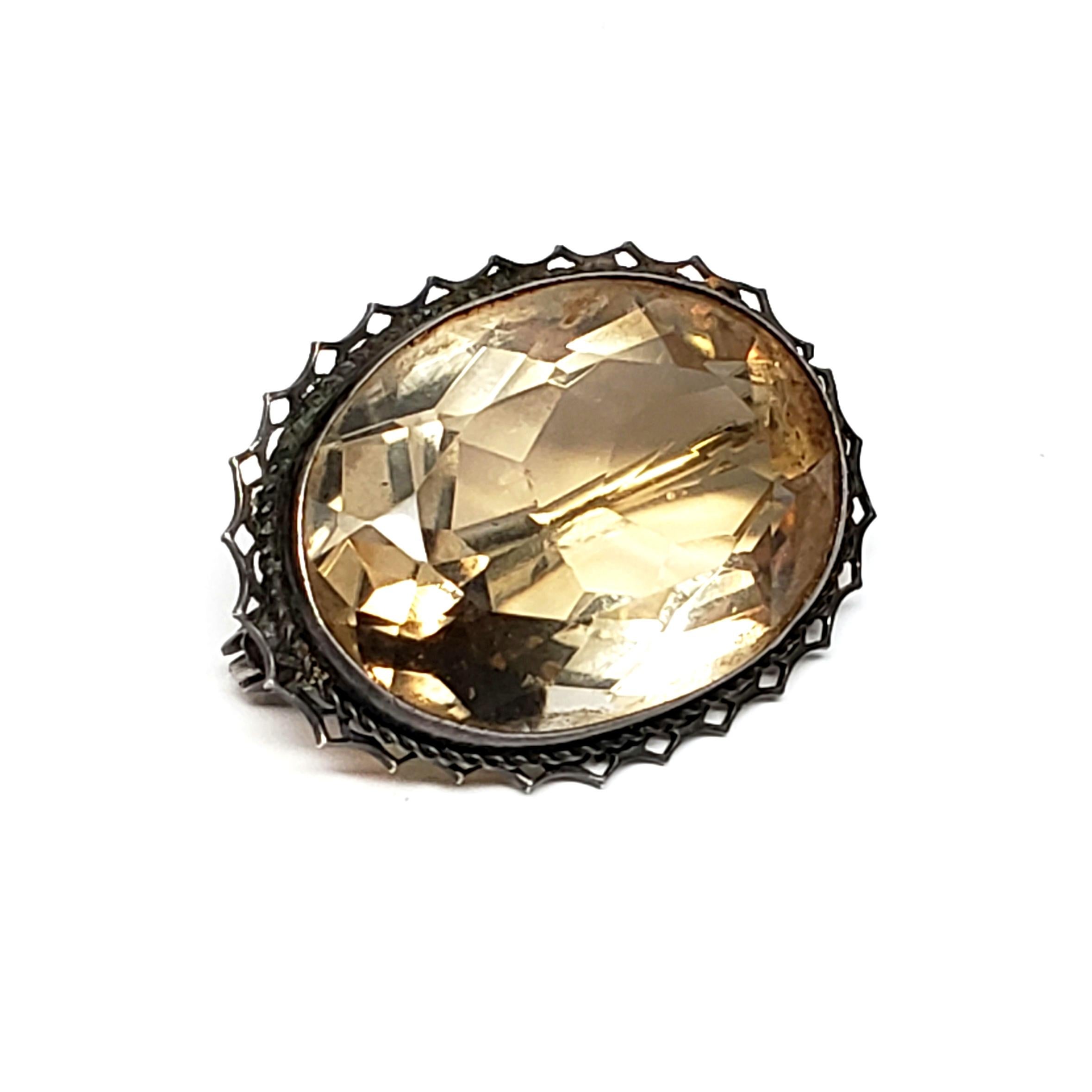 Sterling silver and citrine pin made in Germany.

Beautifully simple and elegant pin features a large oval faceted citrine bezel set in a delicate frame.

Measures 1 1/8