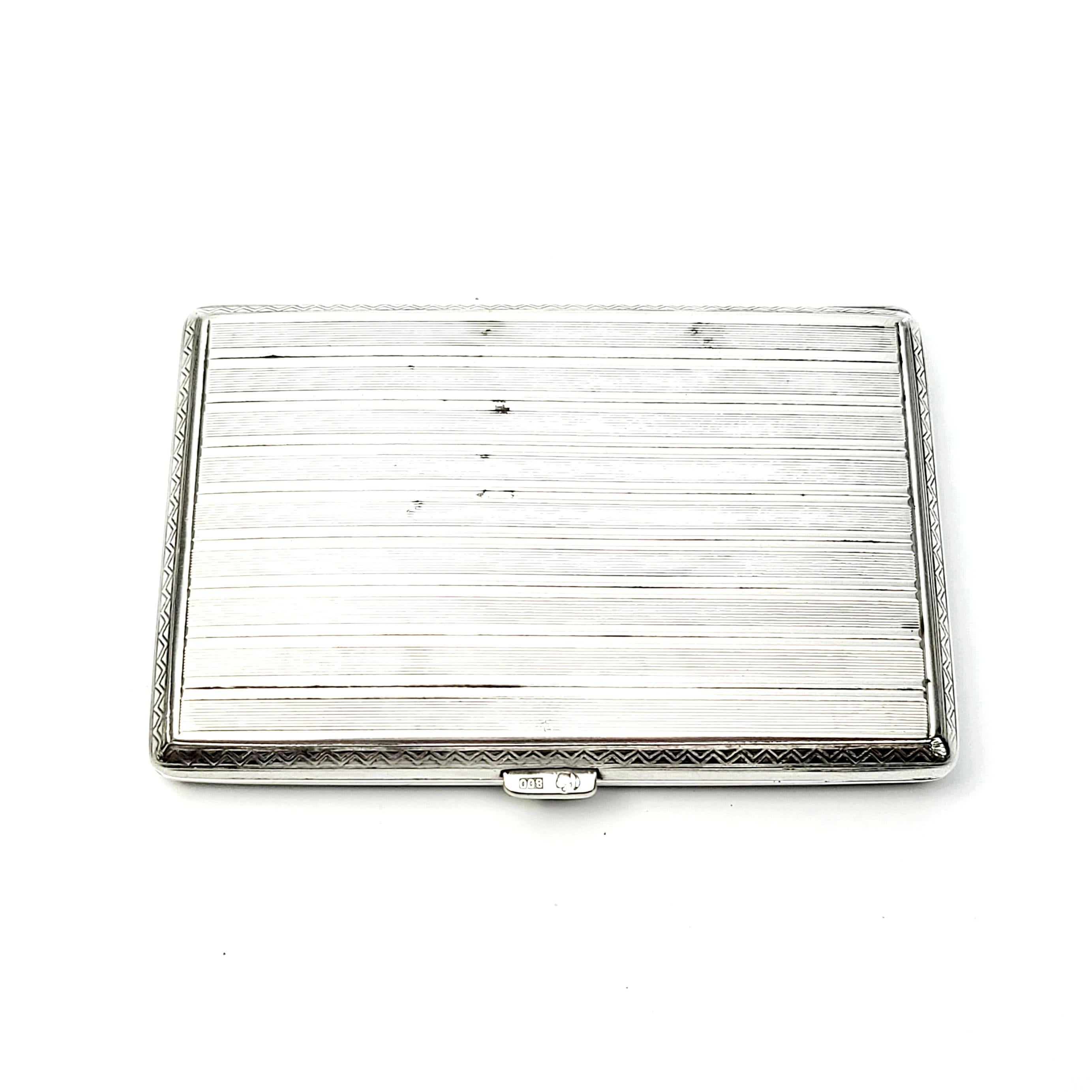 Vintage German 800 silver cigarette case.

This piece features a banded etched striped design on both sides with a triangular design border. Push button mechanism to open. Elastic bands on interior.

Measures approximate 3 3/8