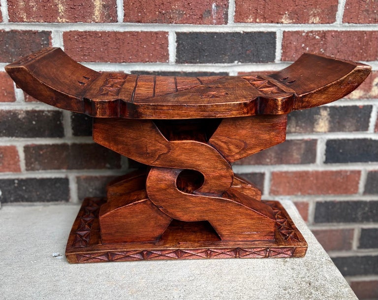 Vintage Ashanti cedar 'Wisdom Knot' stool, handcrafted in Ghana.

The stool is intricately carved from a single piece of wood and features Adinkra symbolism representing Ghanaian lore. The central symbol depicted is Nyansapo, the Wisdom Knot, an