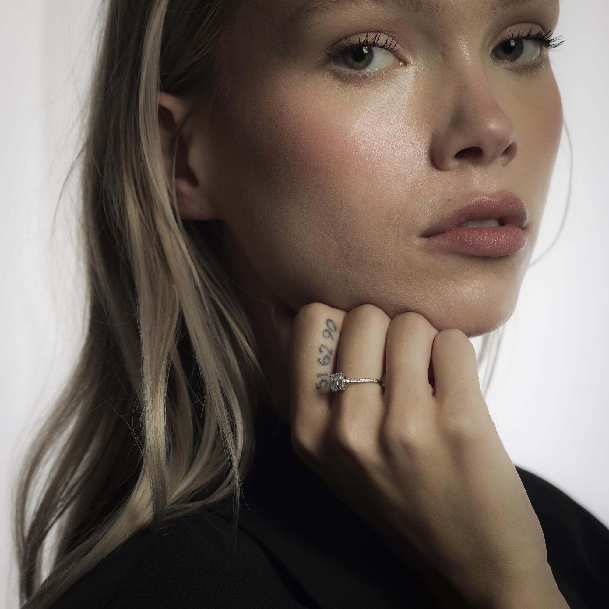This vintage platinum Danhov ring from the 1990’s features a 1.01-carat emerald cut diamond of exceptional E color and VS1 clarity, certified by GIA #11951623. Twenty round brilliant cut diamonds, totaling approximately .15 carats in E-F color and