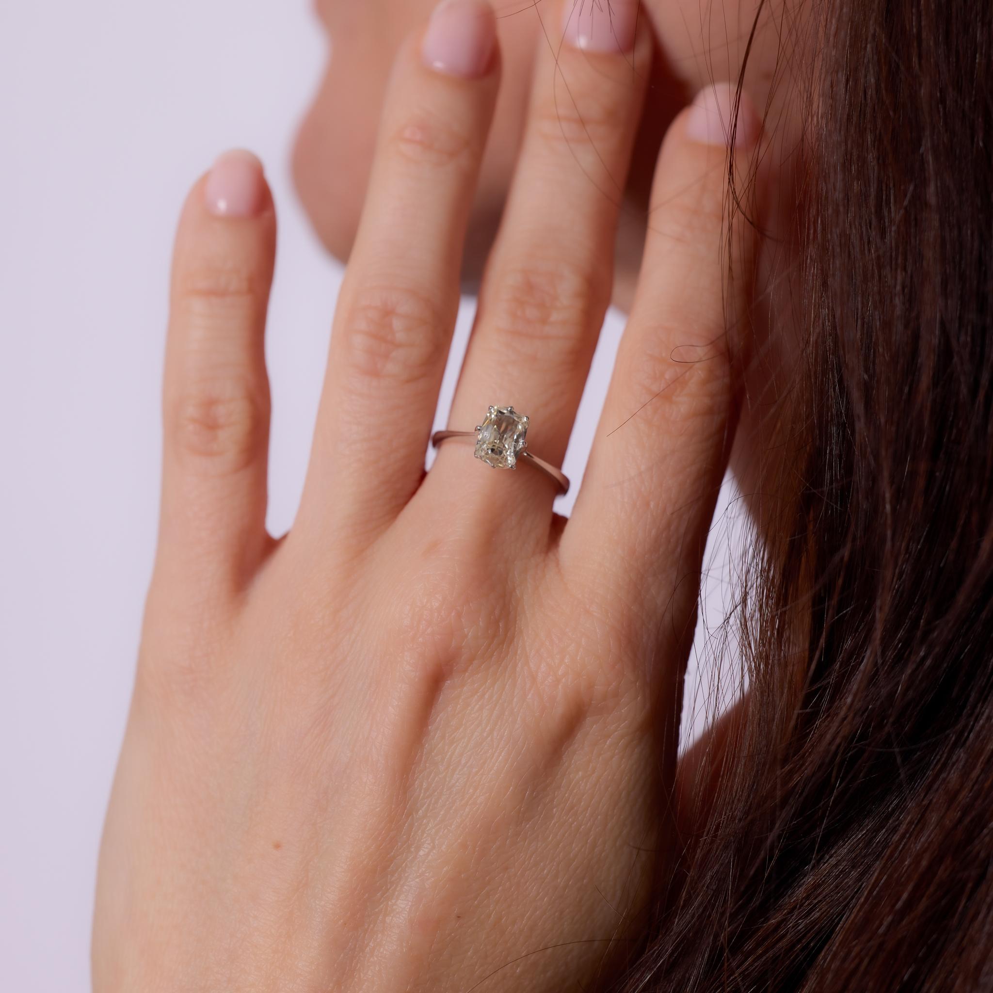 Crafted in the 1980s, this vintage engagement ring showcases a GIA-certified 1.01-carat elongated old mine cut diamond, graded K color and SI2 clarity. The distinctive faceting and soft, cushion-like shape of the center stone highlight its antique