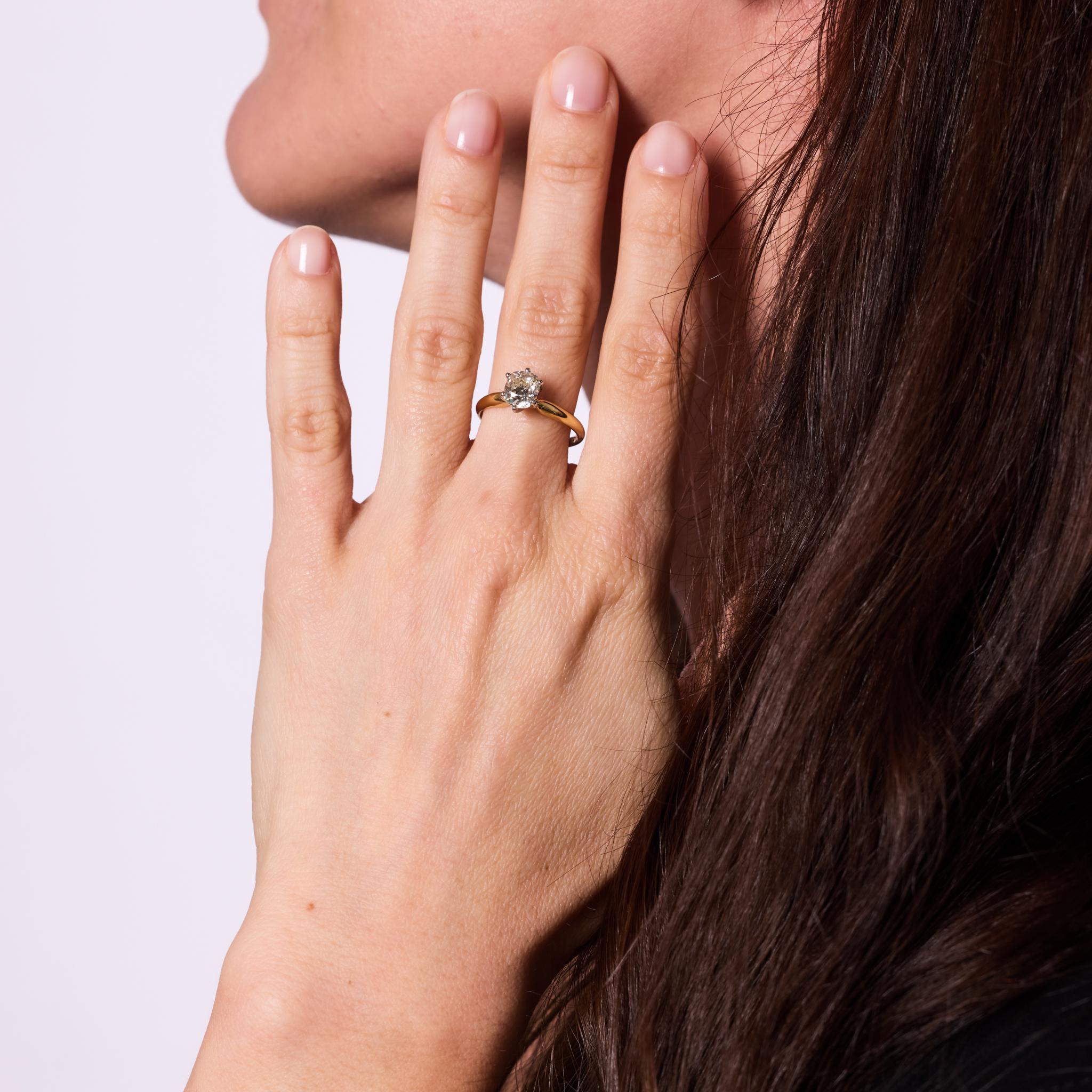Crafted in the 1990s, this vintage ring centers a GIA-certified 1.26-carat old mine cut diamond, graded M color and VS1 clarity. The diamond’s antique faceting and warm tone are enhanced by a timeless 18k yellow gold band paired with a platinum