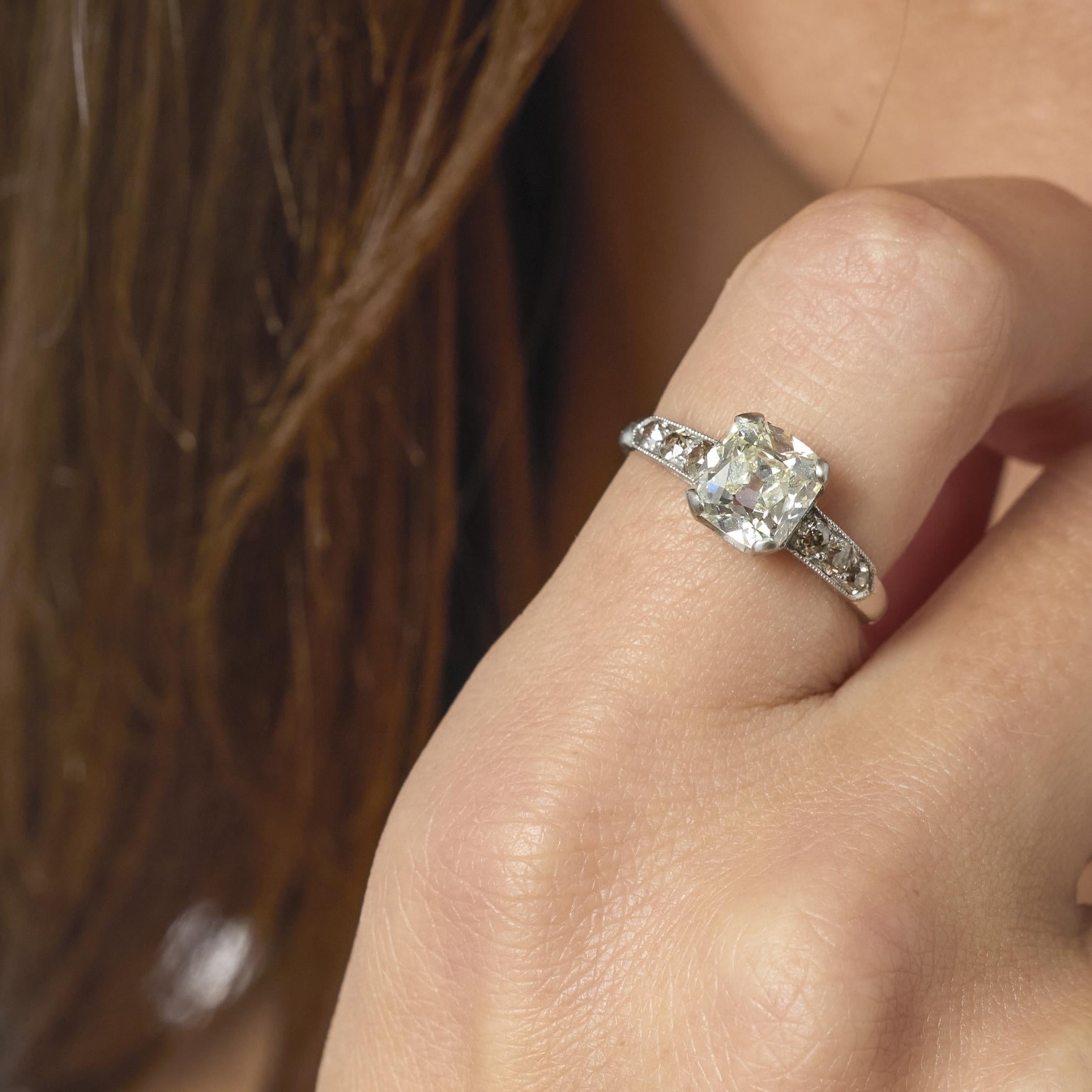 Luminoso tesoro dell'epoca Art Deco, questo anello di fidanzamento vintage in platino è incentrato su un diamante taglio old mine da 2,07 carati certificato GIA, il cui fuoco morbido e romantico irradia un fascino senza tempo. La calda tonalità del