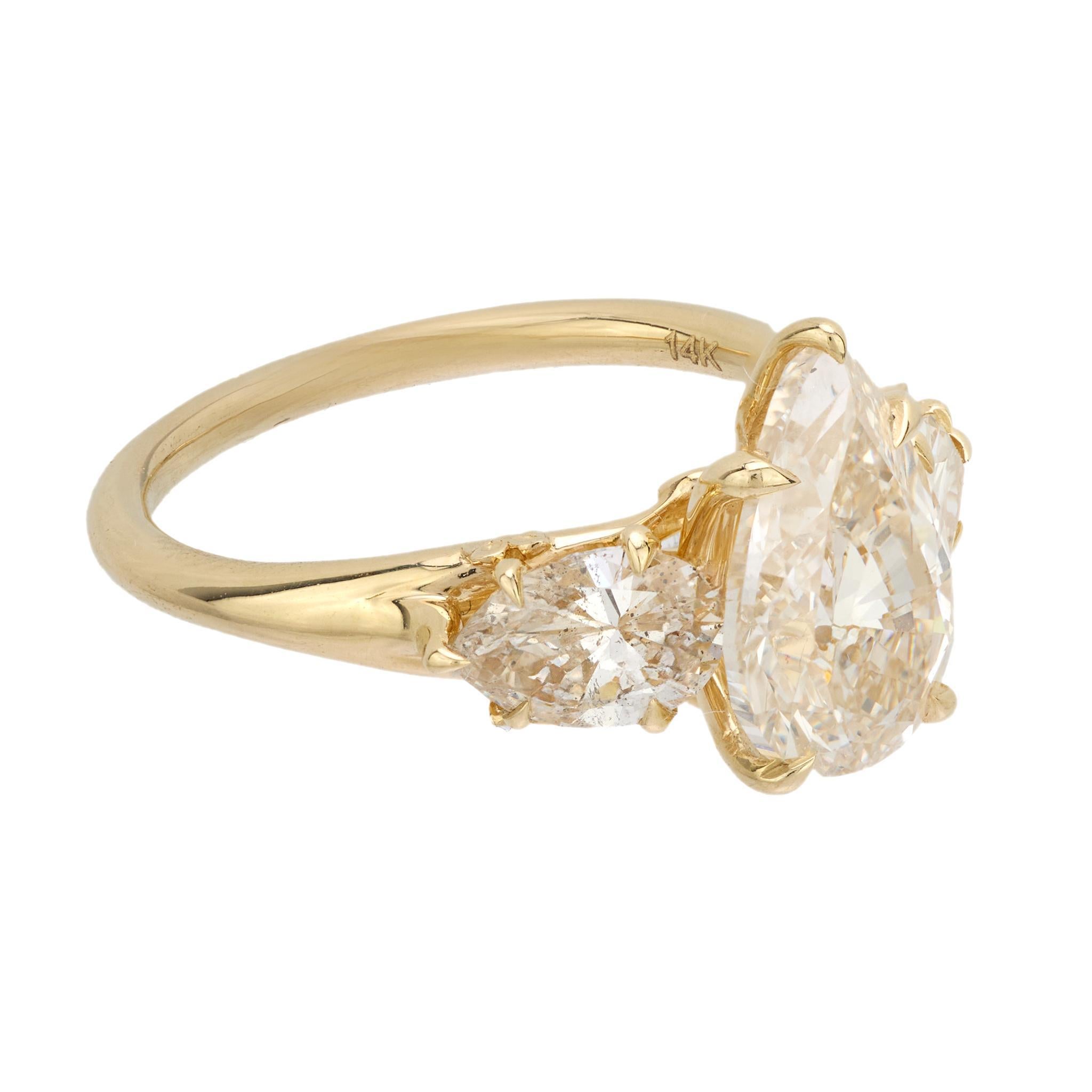 This bold vintage engagement ring features a 2.50 carat GIA-certified pear cut diamond flanked by matching pear-shaped side stones. Set in warm 14k yellow gold, its golden hue and soft sparkle evoke distinctive 1990s charm.