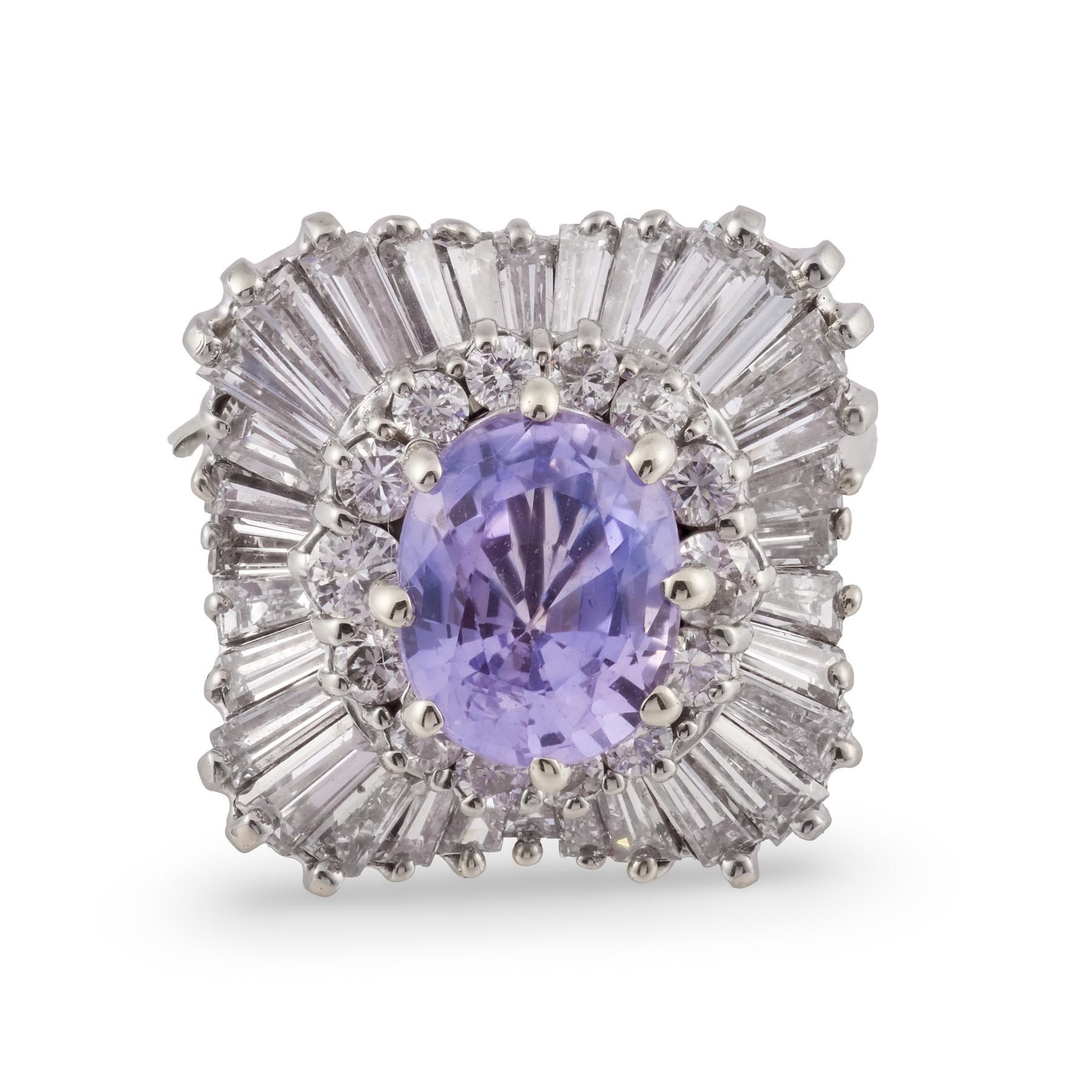 Dieser Ring aus Weißgold im Vintage-Stil präsentiert einen fesselnden Ceylon-Saphir in leuchtender Farbe, umrahmt von einer außergewöhnlichen Reihe sich verjüngender Baguette- und runder Diamanten, die für auffallende Bewegung, Brillanz und