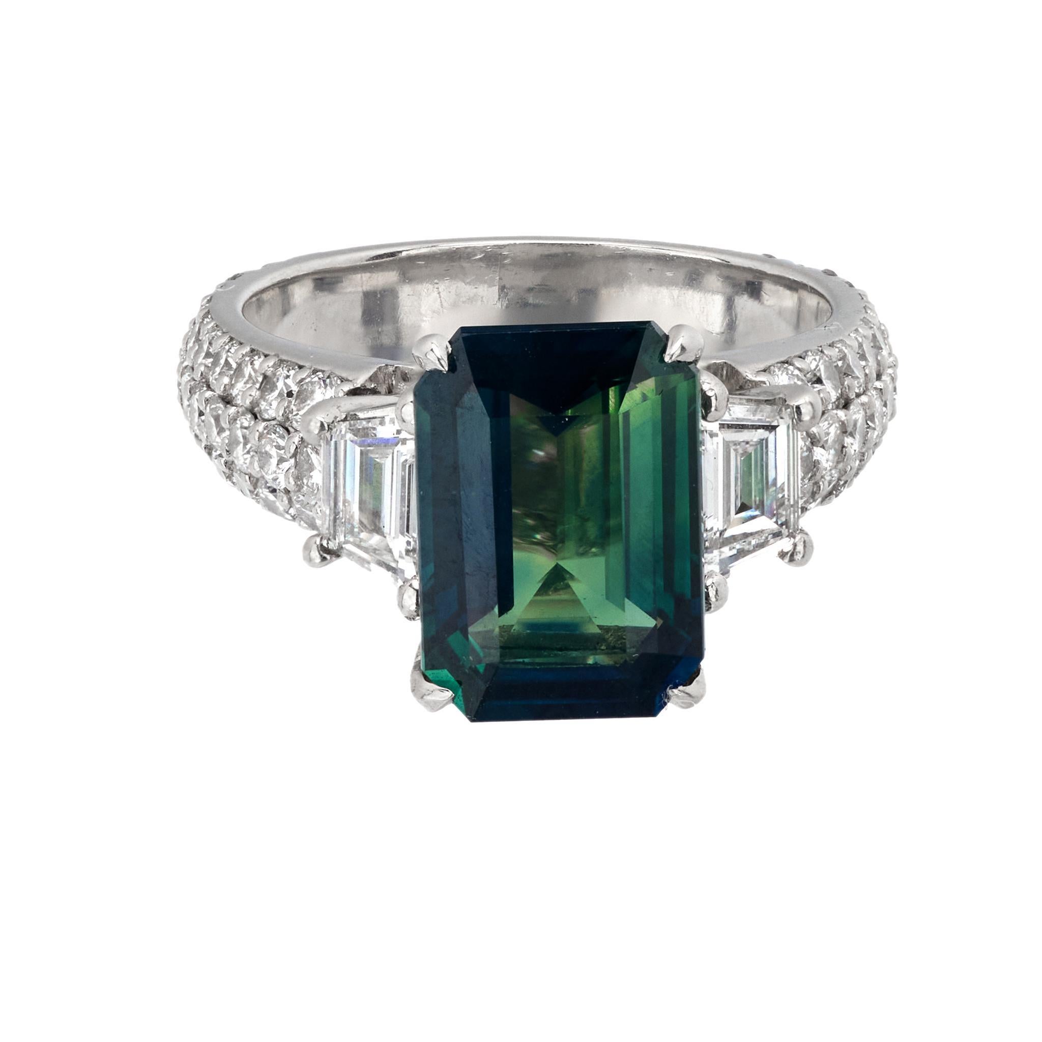 This vintage platinum cocktail ring features a striking GIA-certified 4.20-carat emerald-cut greenish-blue sapphire from Madagascar, with no heat treatment. Accented by two trapezoid cut diamonds and 68 round brilliant cut diamonds totaling