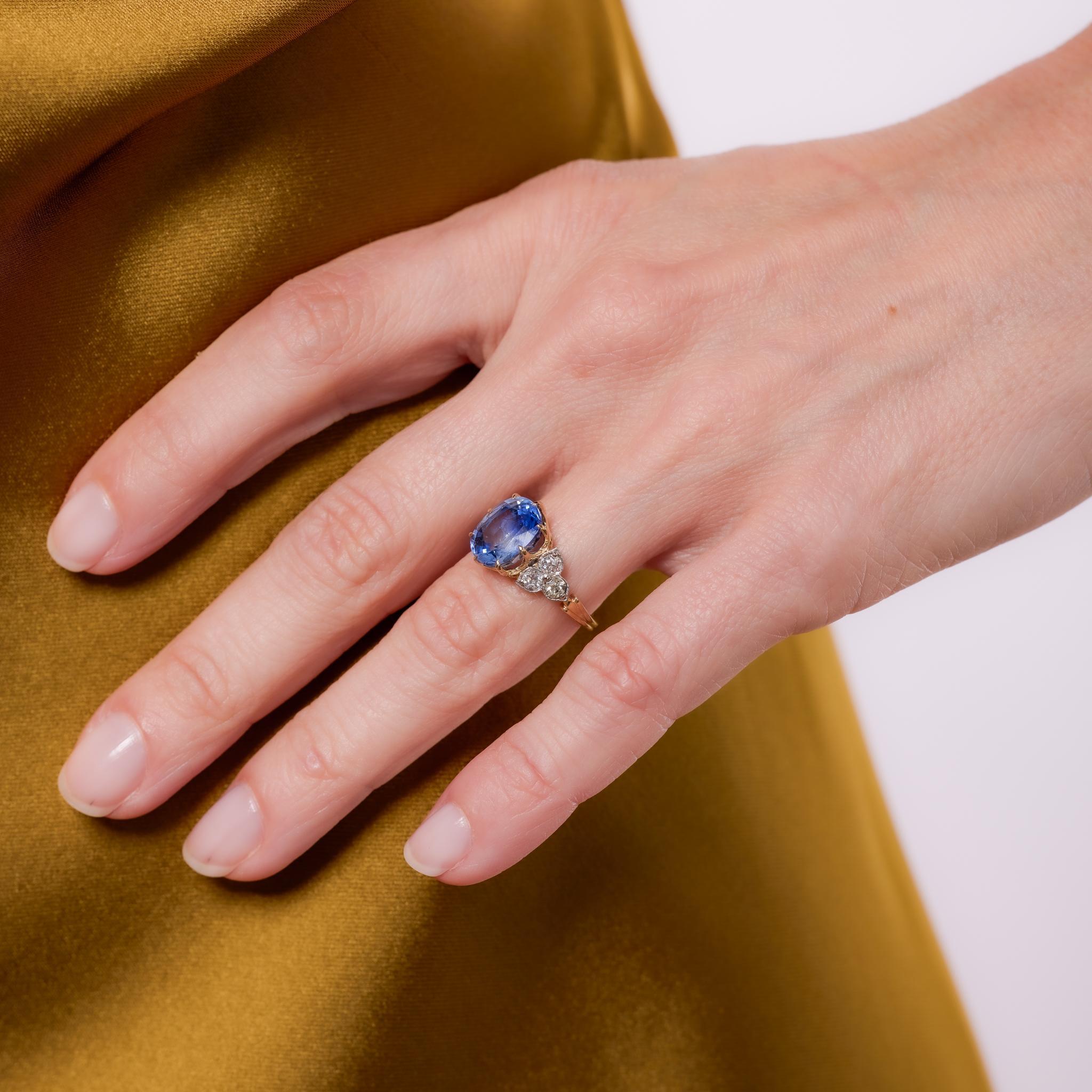 Fabriquée dans les années 1980, cette bague vintage met en valeur un saphir coussin de Ceylan de 4,55 carats, certifié par la GIA, traité à la chaleur pour rehausser son ton profond et vif. Il est rehaussé de six diamants de taille européenne