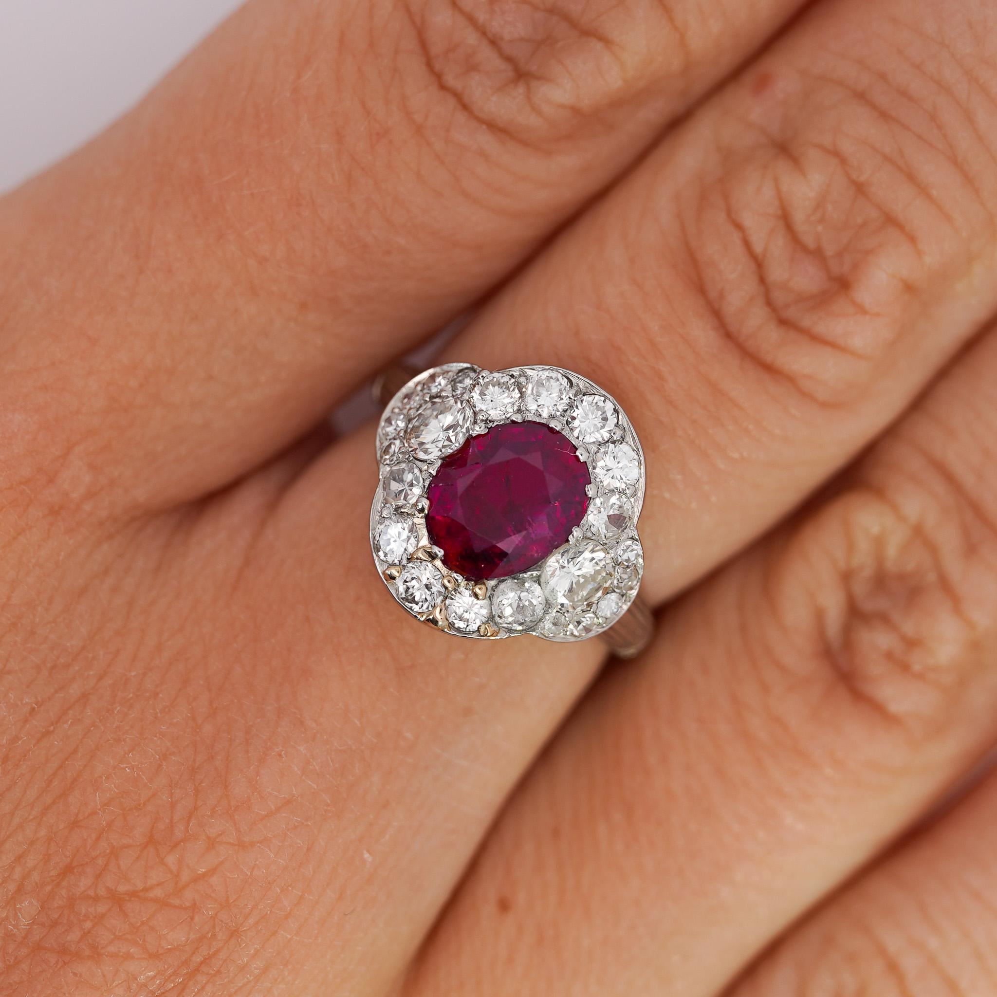 This vintage platinum ring features a stunning GIA-certified 2.3 carat oval-cut no heat Burma ruby surrounded by single, brilliant, and old Euro-cut diamonds totaling approximately 2 carats. 

Details:
Item Type: Vintage Engagement Ring
Metal: