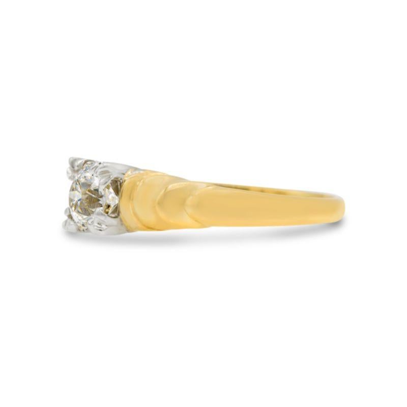 A little gold goes a long way for this twinkling two-tone solitaire ring. The center half carat old European cut diamond is small but mighty, and full of light. Fishtail prongs give this yellow gold engagement ring style its distinct Art Deco look.