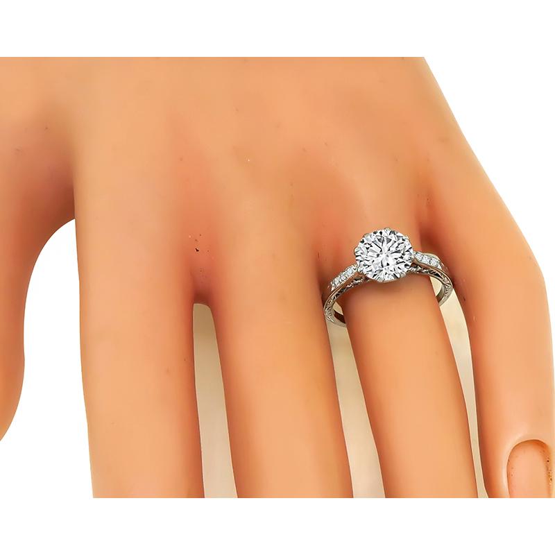 This is a beautiful platinum engagement ring. The ring is centered with a sparkling GIA certified old mine cut diamond that weighs 1.96ct. The color of the diamond is E with SI1 clarity. The center diamond is accentuated by dazzling round cut