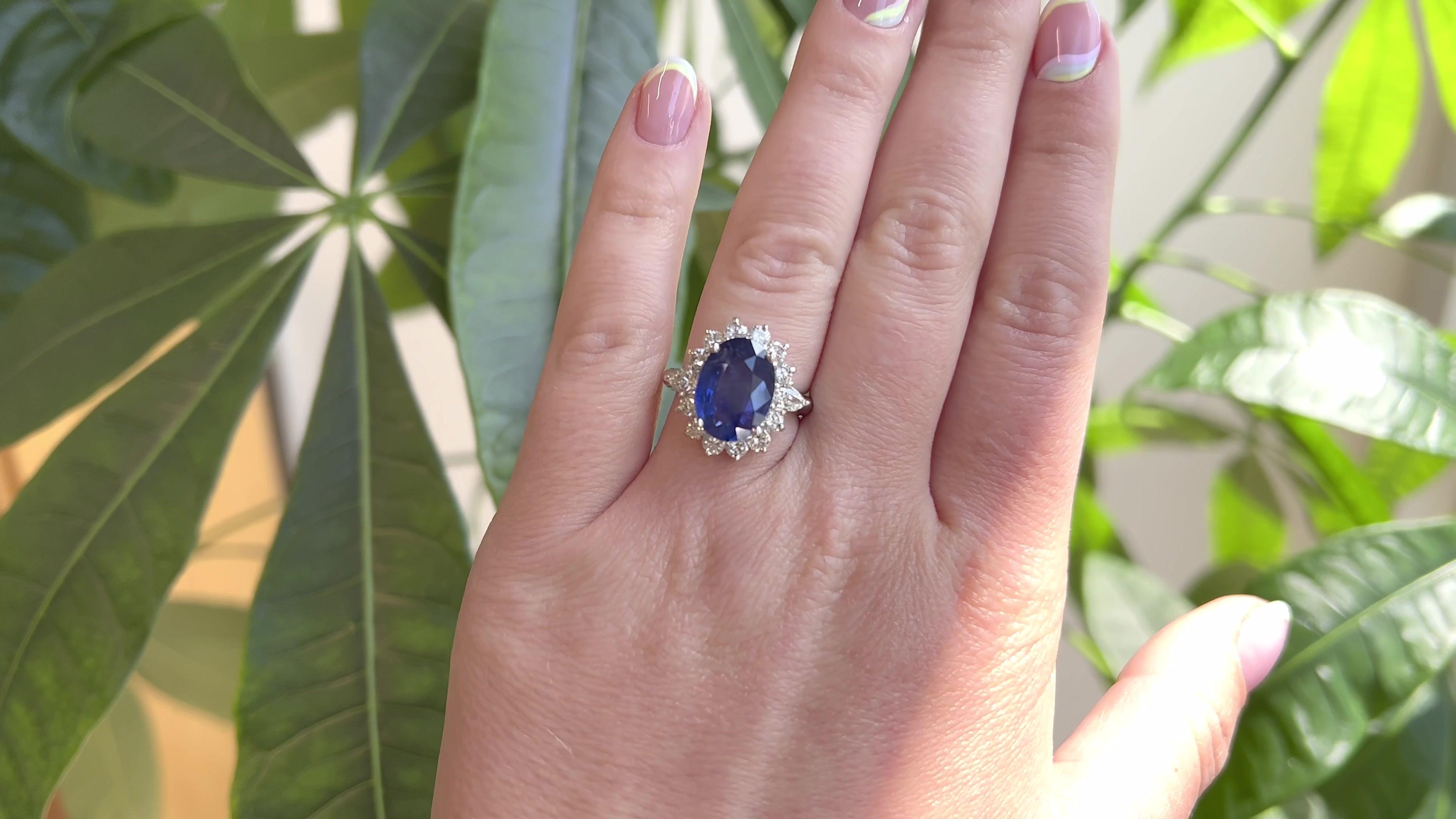 One Vintage GIA Ceylon Oval Sapphire Diamond Platinum Cluster Ring. Featuring one GIA certified oval shaped sapphire of 6.02 carats, accompanied with certificate #6227417803 stating the sapphire is of Ceylon origin. Accented by two pear shape cut