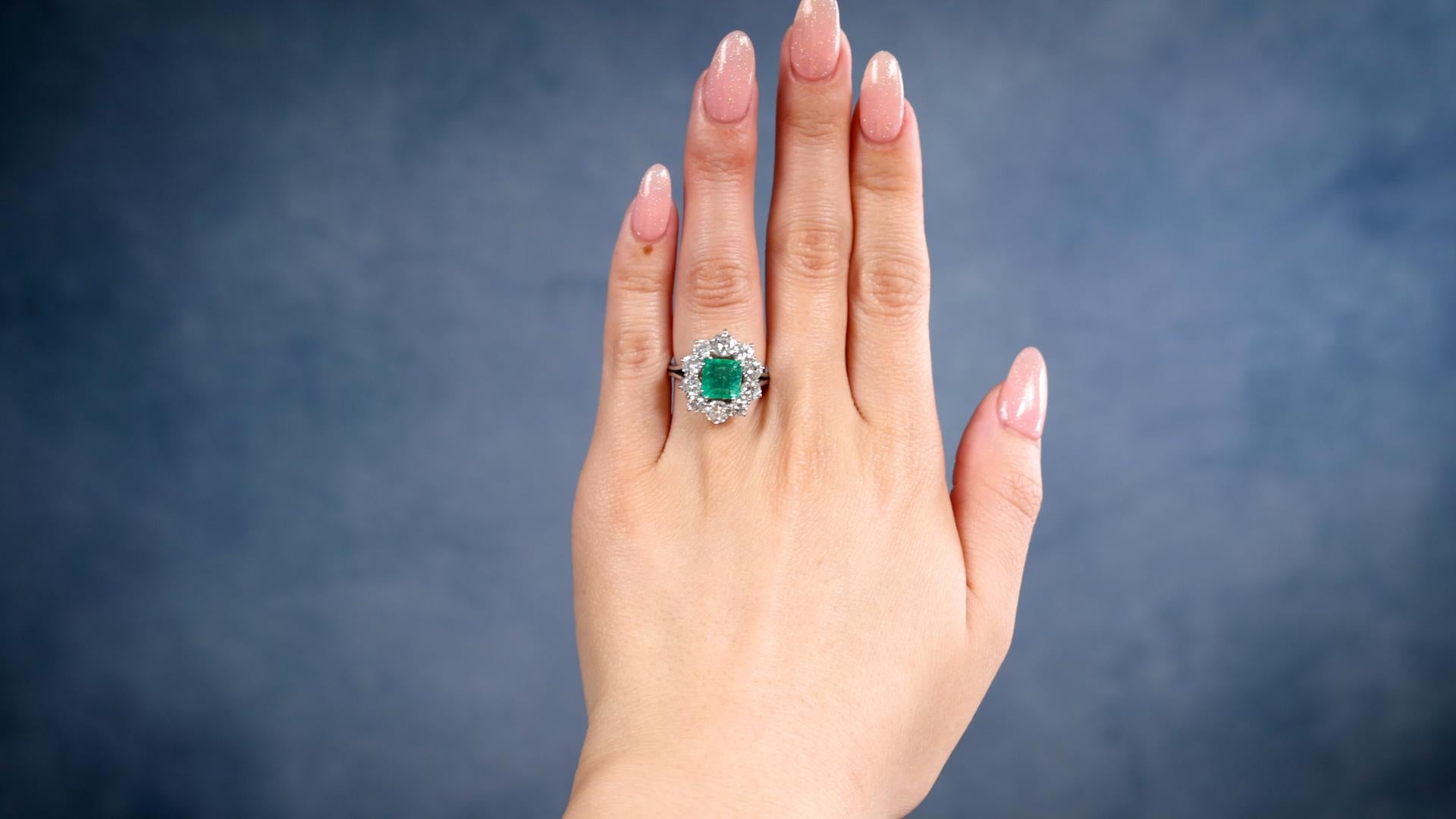 One Vintage GIA Colombian Emerald Diamond Platinum Cluster Ring. Featuring one square step cut emerald weighing approximately 1.50 carats, accompanied by GIA #2235177987 stating the stone is of Colombian origin. Accented by 10 round brilliant cut