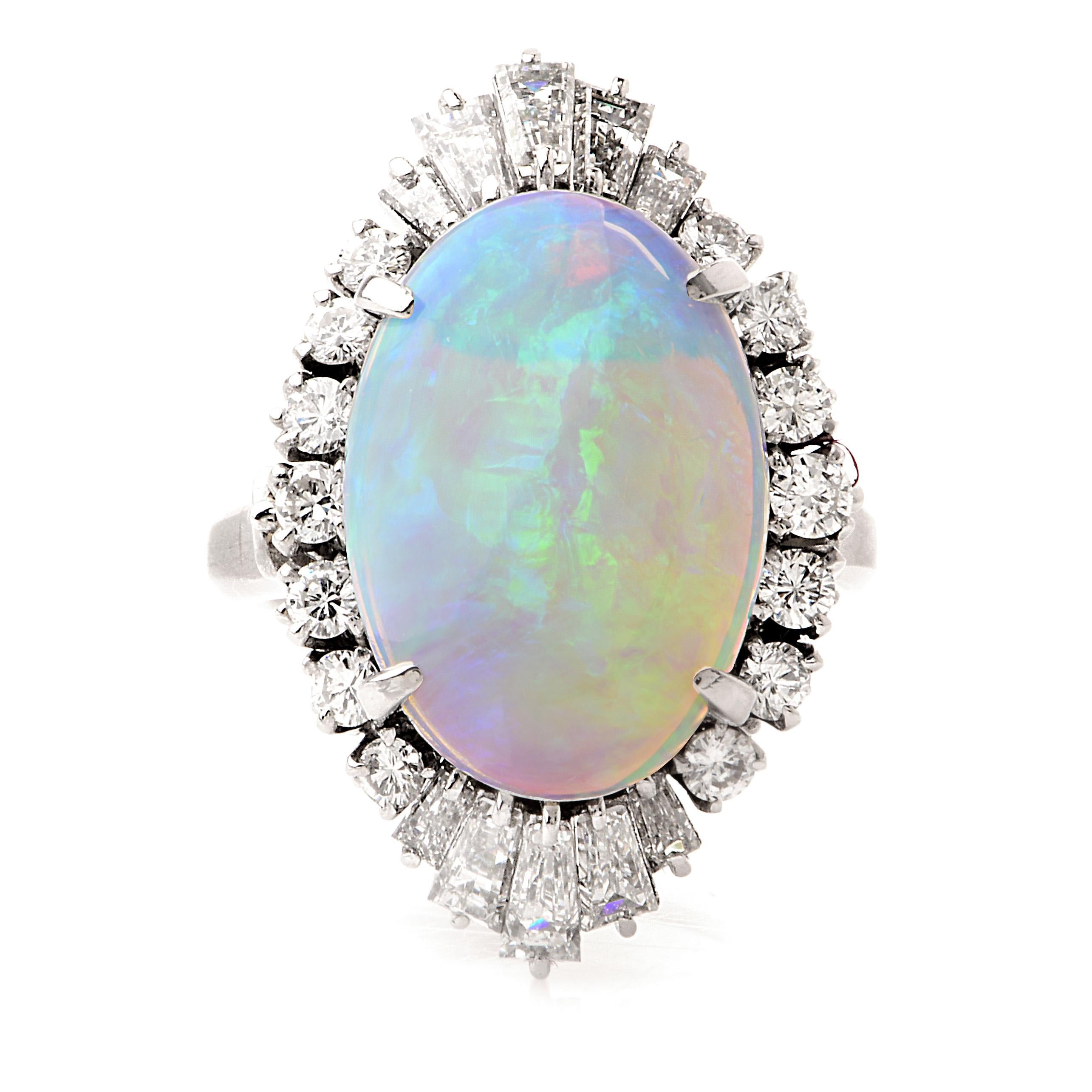 This stunning diamond and opal cocktail ring is crafted in solid platinum, weighing 10.3  grams and measures 24mm x 13mm high. Showcasing a prominent four-prong set cosmic GIA certified  natural opal, weighing approximately, 5.40 carats. Surrounded