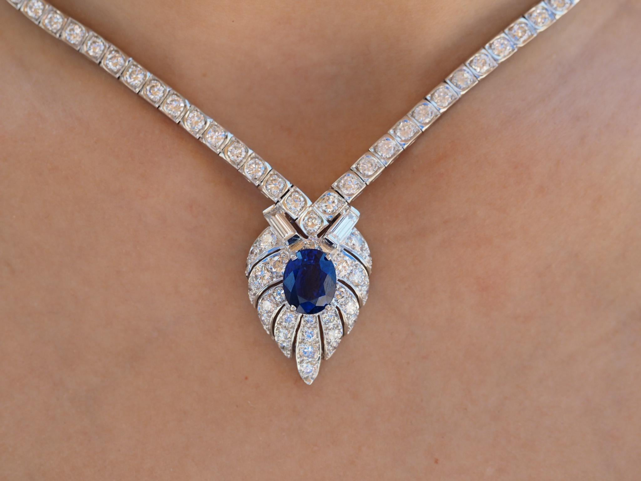 This exquisite blue sapphire and diamond necklace is sure to make you feel like royalty. A royal blue natural GIA sapphire is set in the center held by four prongs flooded with diamonds all around. The pendant itself consist of two large baguettes