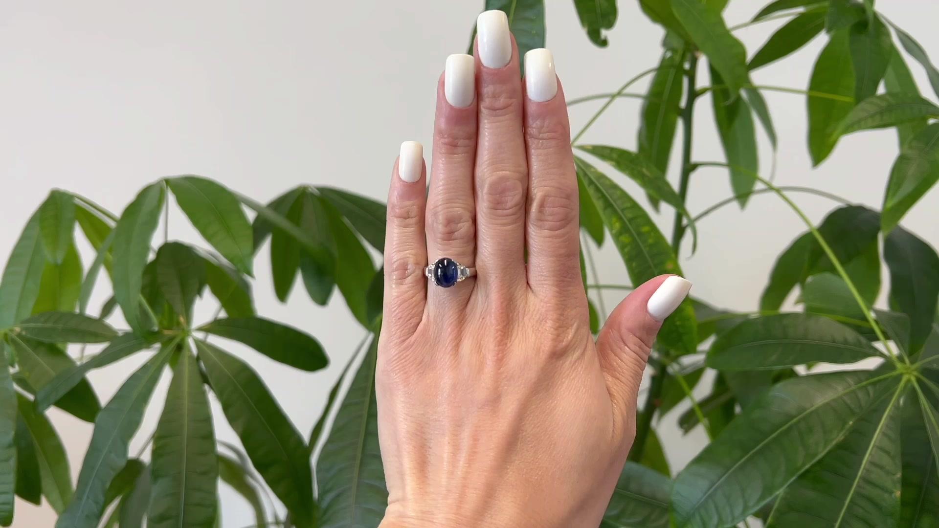 One Vintage GIA Thai Sapphire Diamond 18k White Gold Ring. Featuring one GIA cabochon cut sapphire of approximately 4.40 carats, accompanied with GIA certificate #5222869358 stating the sapphire is of Thai origin. Accented by two half-moon step cut