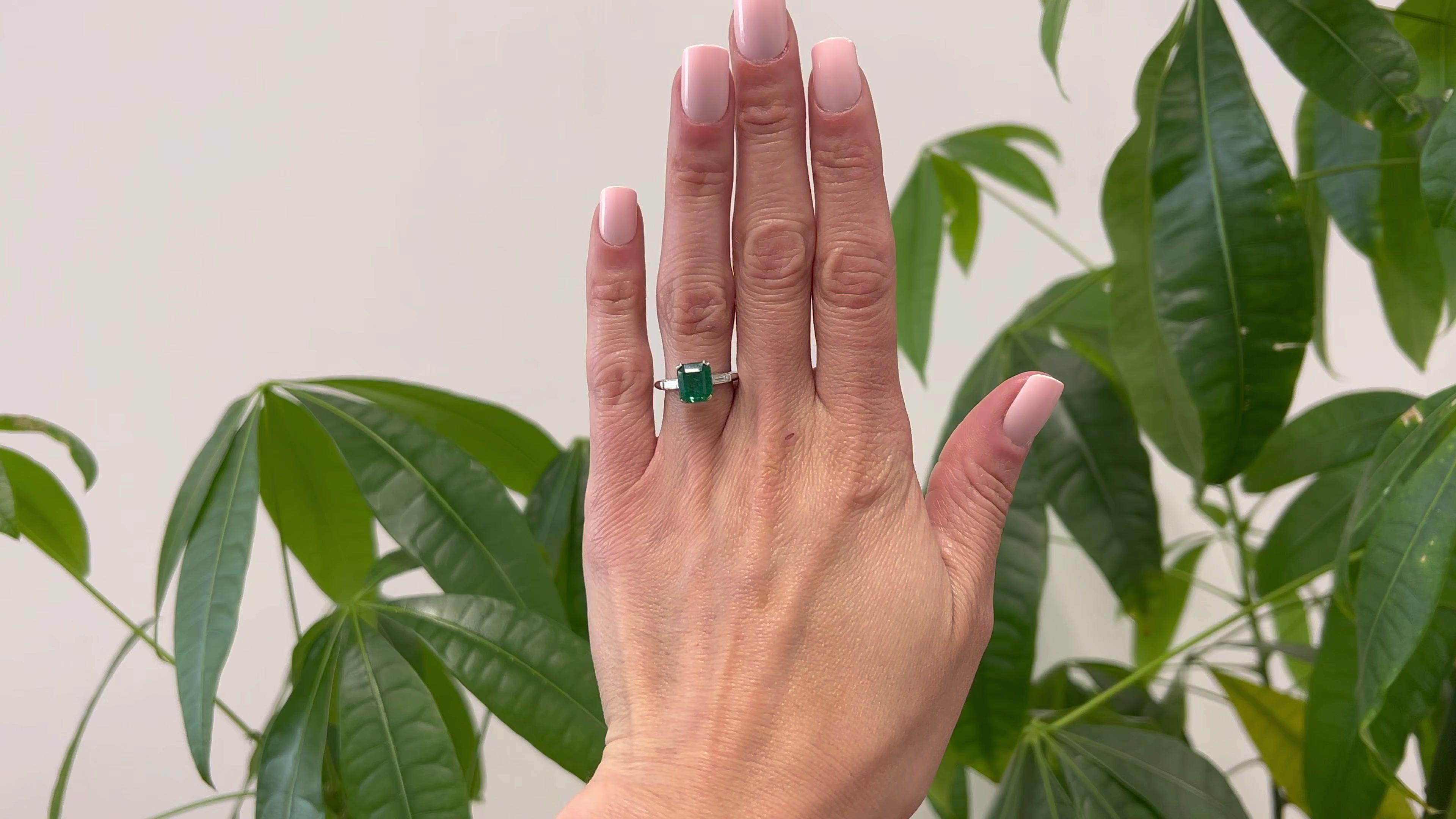One Vintage GIA Zambian Emerald and Diamond Platinum Ring. Featuring one GIA octagonal step cut emerald weighing 2.75 carats, accompanied with GIA #2225988712 stating the emerald is of Zambian origin. Accented by two baguette cut diamonds with a