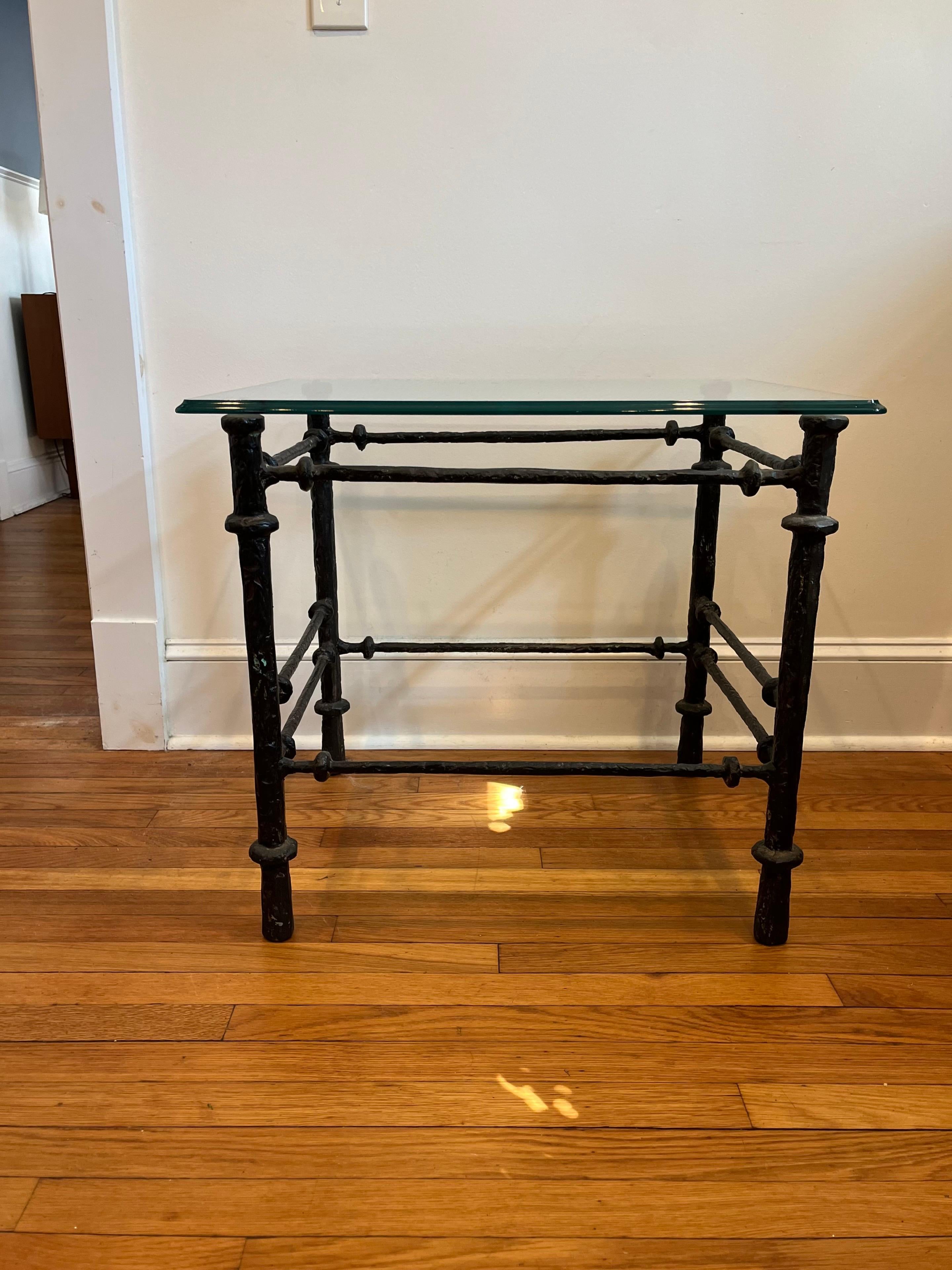 Mesa auxiliar o de cóctel escultórica de metal fundido de los años 70, poco común, con tapa de cristal a la manera de Diego Giacometti.

La forma textural ejecutada con arte encarna fielmente el estilo, la estética y la técnica característicos de