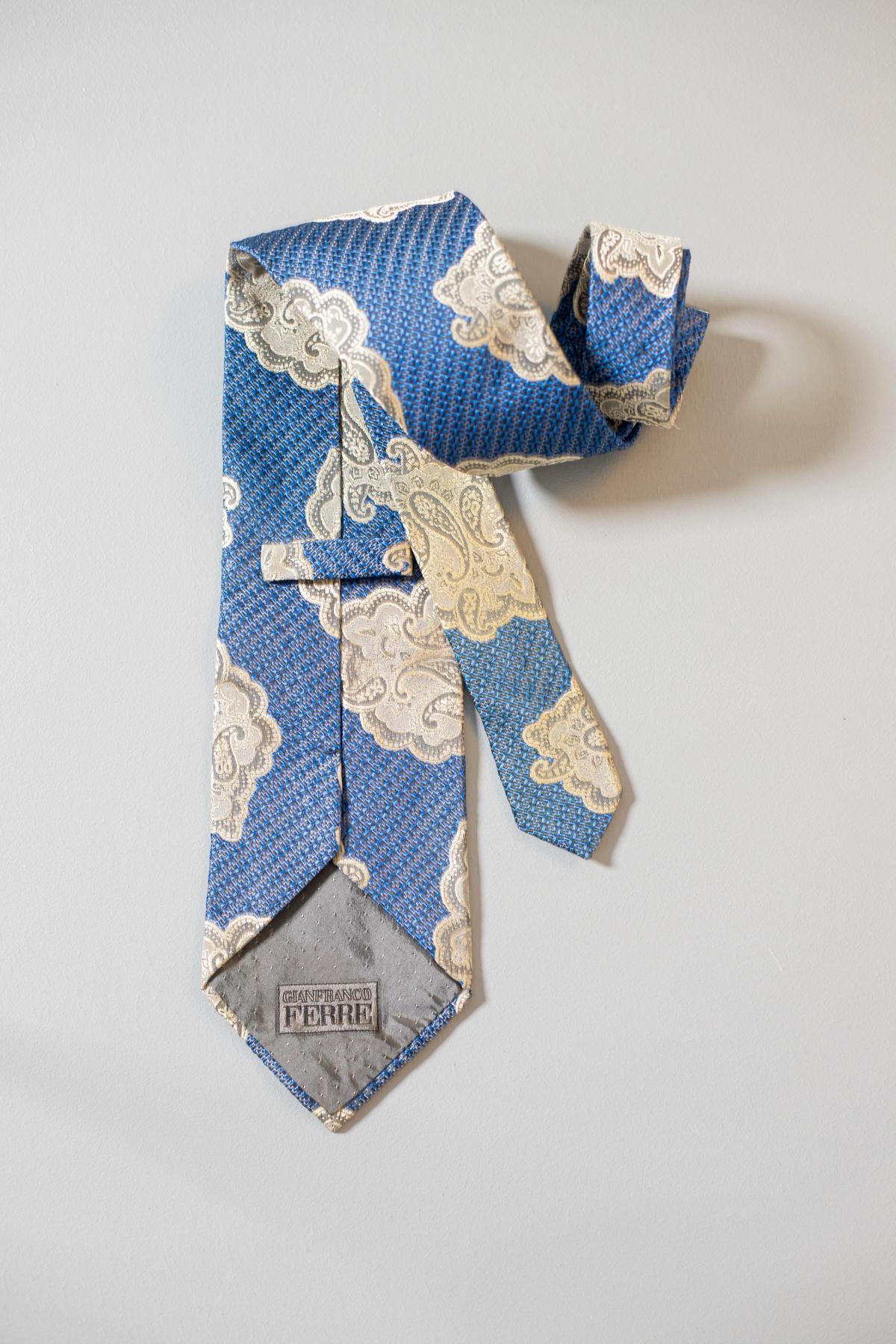 This all-silk vintage tie designed by Gianfranco Ferré is elegant and classy. Its white motifs on a light blue background make it classic, fresh and elegant. This tie is the ideal accessory for a summer informal lunch.