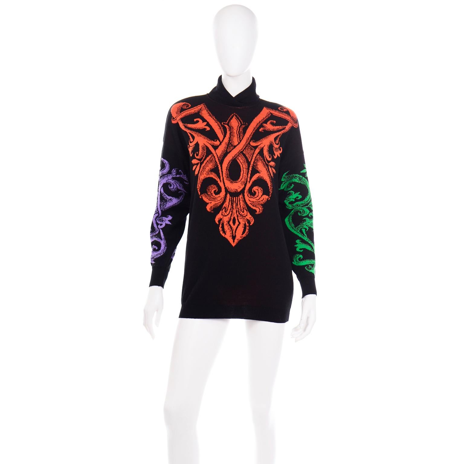 This vintage 1980's or early 1990's Gianni Versace wool knit sweater has beautiful and bright colorful woven abstract baroque details in shades of orange, green, red and purple. The front of the sweater has an orange design, the back has a red one,