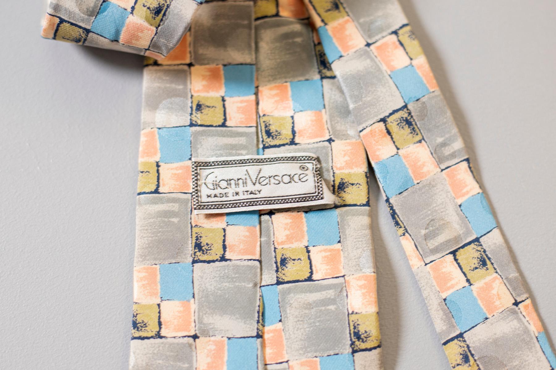 Designed by the great Gianni Versace and made in Italy, this vintage tie is a must-have. This tie is in silk, and its pattern recalls the shape of a square. Its soft and pastel colours make it perfect for an informal summer afternoon with your