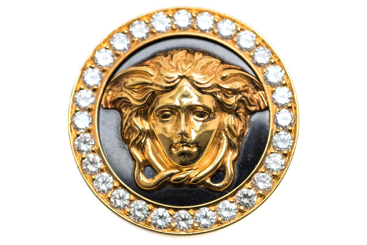 A vintage pair of 18 karat yellow gold earrings by Gianni Versace. Central cameo of Medusa on a black enamel background with a border of brilliant cut diamonds. Post and clip fittings. Signed GIANNI VERSACE 18K 750 and numbered 019.
Measures 30mm