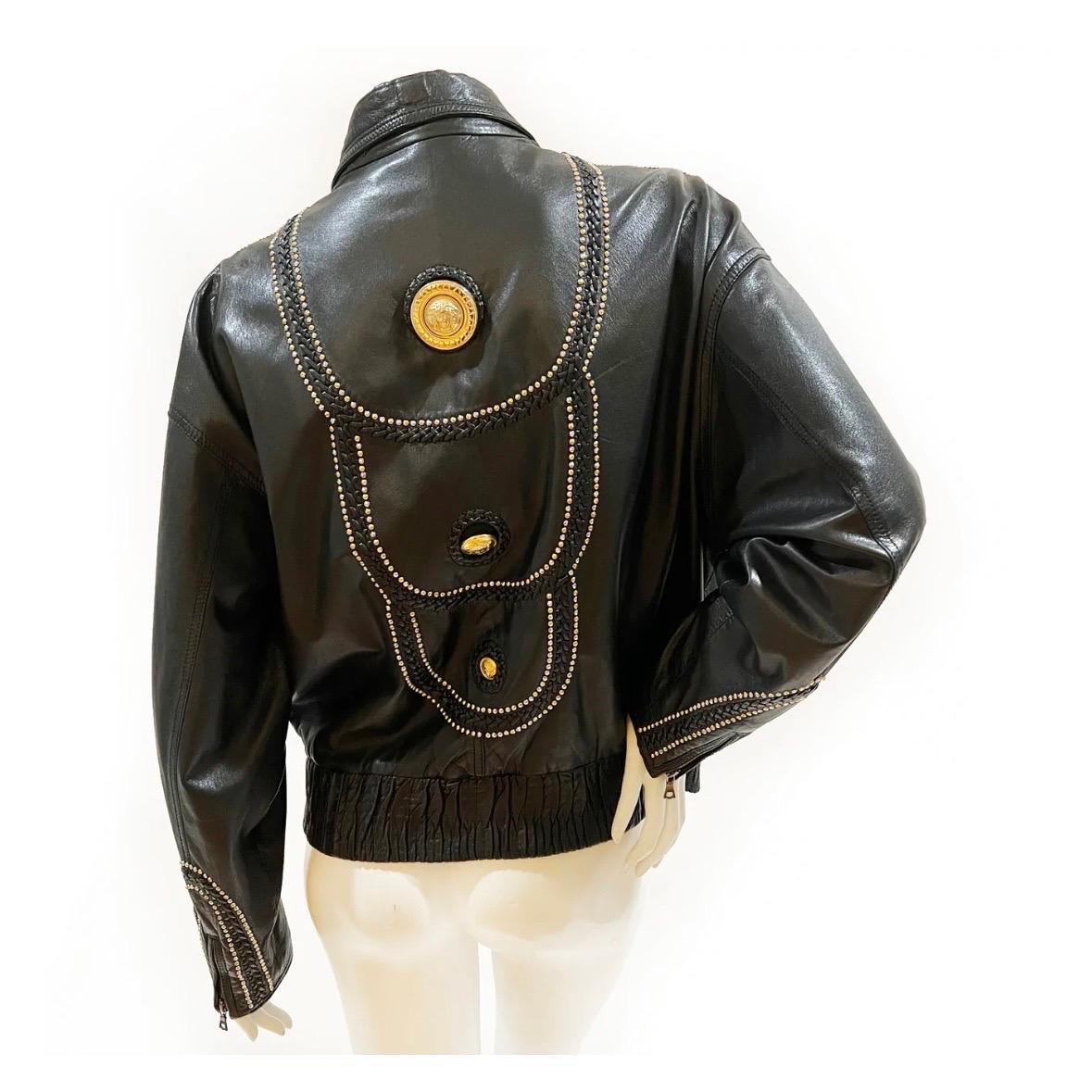 Vintage Embellished Leather Jacket by Gianni Versace
1992/1993
Made in Italy 
Black leather 
Front zip closure 
Elastic bottom hem 
Gold and silver metal stud detail
Decorative stitching throughout 
Gold-metal various sized Medusa medallions 
Dual