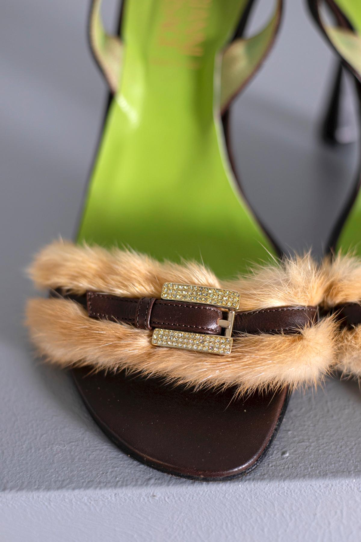 Gianni Versace 1990s Vintage Gianni Versace sandals in brown leather, embellished in the toe by a buckle covered with champagne rhinestones and beige fur. Adjustable leather strap with elastic band. Upper in green leather. Real leather sole with