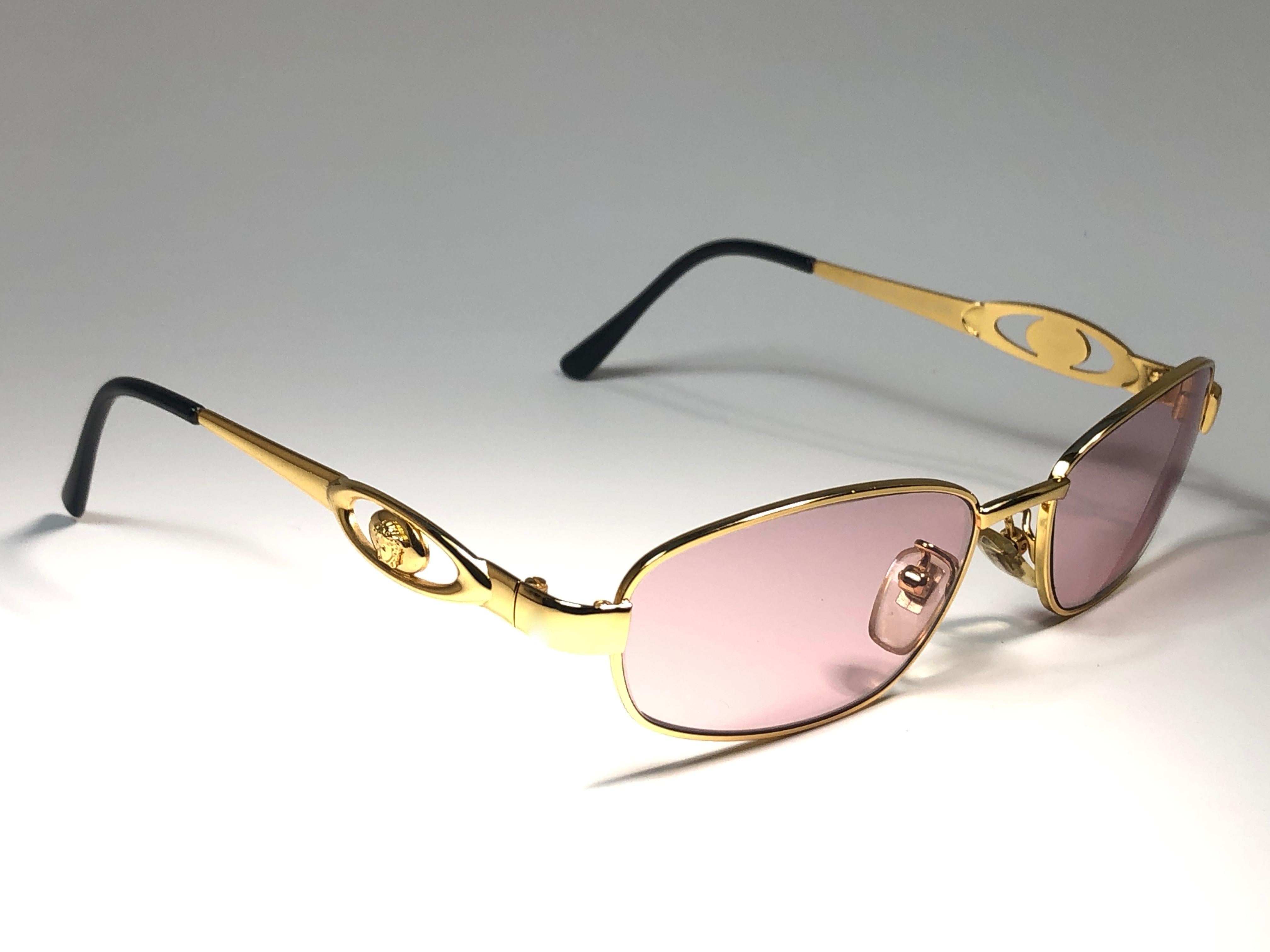 Vintage Gianni Versace small gold frame with rose lenses.


This pair show minor sign of wear due to storage.

Made in italy.