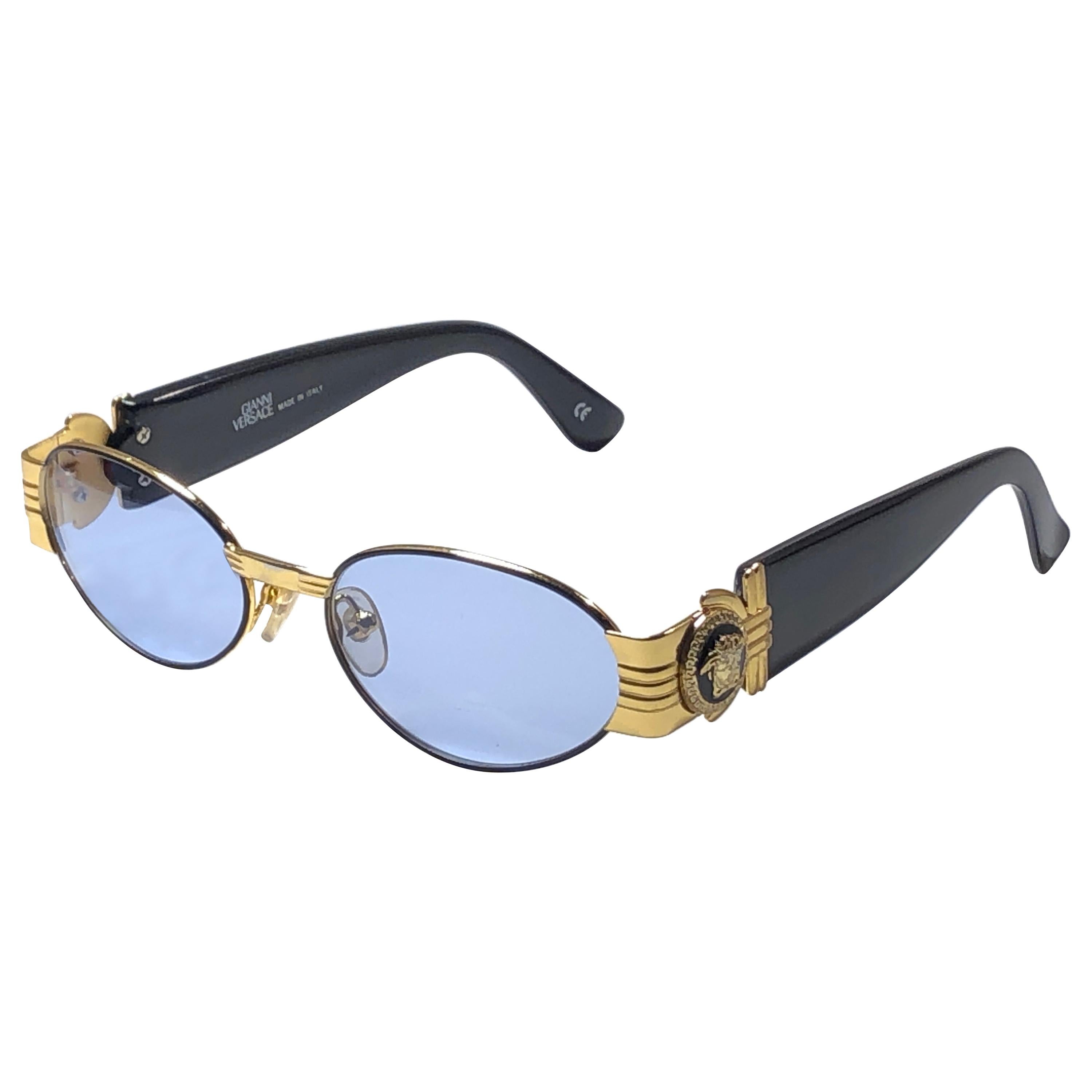 Vintage Gianni Versace small black & gold frame with baby blue lenses.

This pair show minor discoloration on the nose bridge . Please study the pictures prior purchase.

Made in italy.

Front : 13.5 cms

Lens Width : 5 cms

Lens Height : 3.5