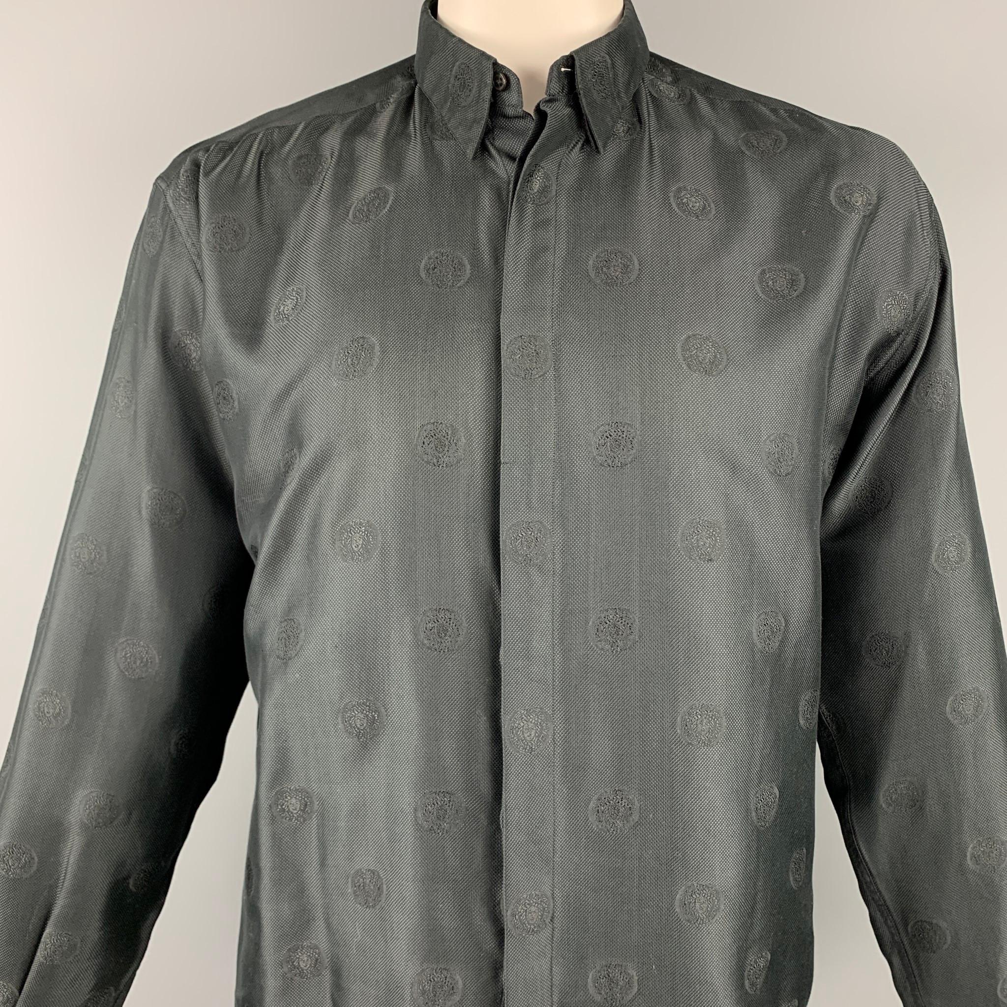 Vintage GIANNI VERSACE long sleeve shirt comes in a black cotton blend with a medusa head print throughout featuring a button down style and a hidden button closure. Made in Italy.

Very Good Pre-Owned Condition.
Marked: 50

Measurements:

Shoulder: