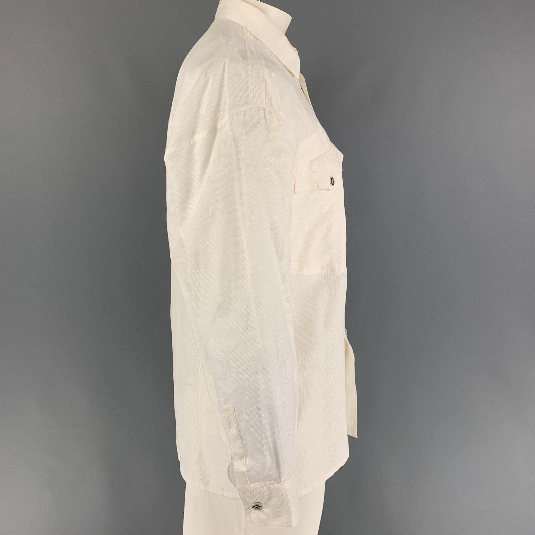 Vintage GIANNI VERSACE long sleeve shirt comes in a white floral cotton featuring a loose fit, silver tone medusa buttons, spread collar, front pockets, and a button up closure. Made in Italy.
New With Tags.
 

Marked:   46 

Measurements: 
