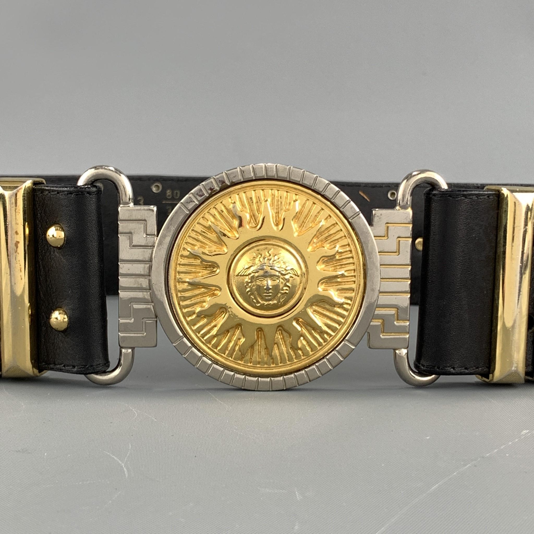 Vintage GIANNI VERSACE belt features a thick studded black leather strap with gold tone Medusa heads, metal loops, and round Medusa Sun medallion buckle. Made in Italy.

Very Good Pre-Owned Condition.
Marked: 80/32  173

Length: 30 in.
Width: 2