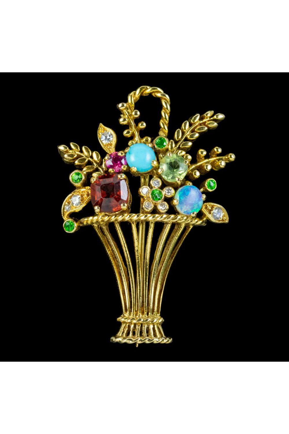 A beautiful 20th Century Giardinetti brooch depicting a vase of flowers and leaves topped with a turquoise, opal, garnet, ruby, peridots, and diamonds. 

Giardinetti is Italian for “Little Gardens”. The jewellery originated in Italy and became a