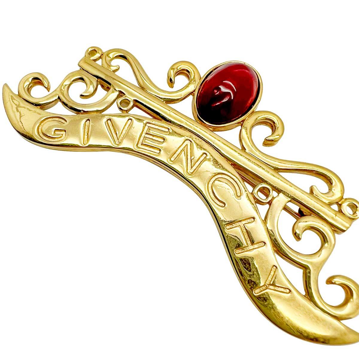 A Vintage Givenchy Cabochon Logo Brooch. What a fabulous find from the house of Givenchy. The scale is impressive and the lavish attention to detail ensures this one demands attention. Scrolls, cabochons and the world-famous moniker of the House