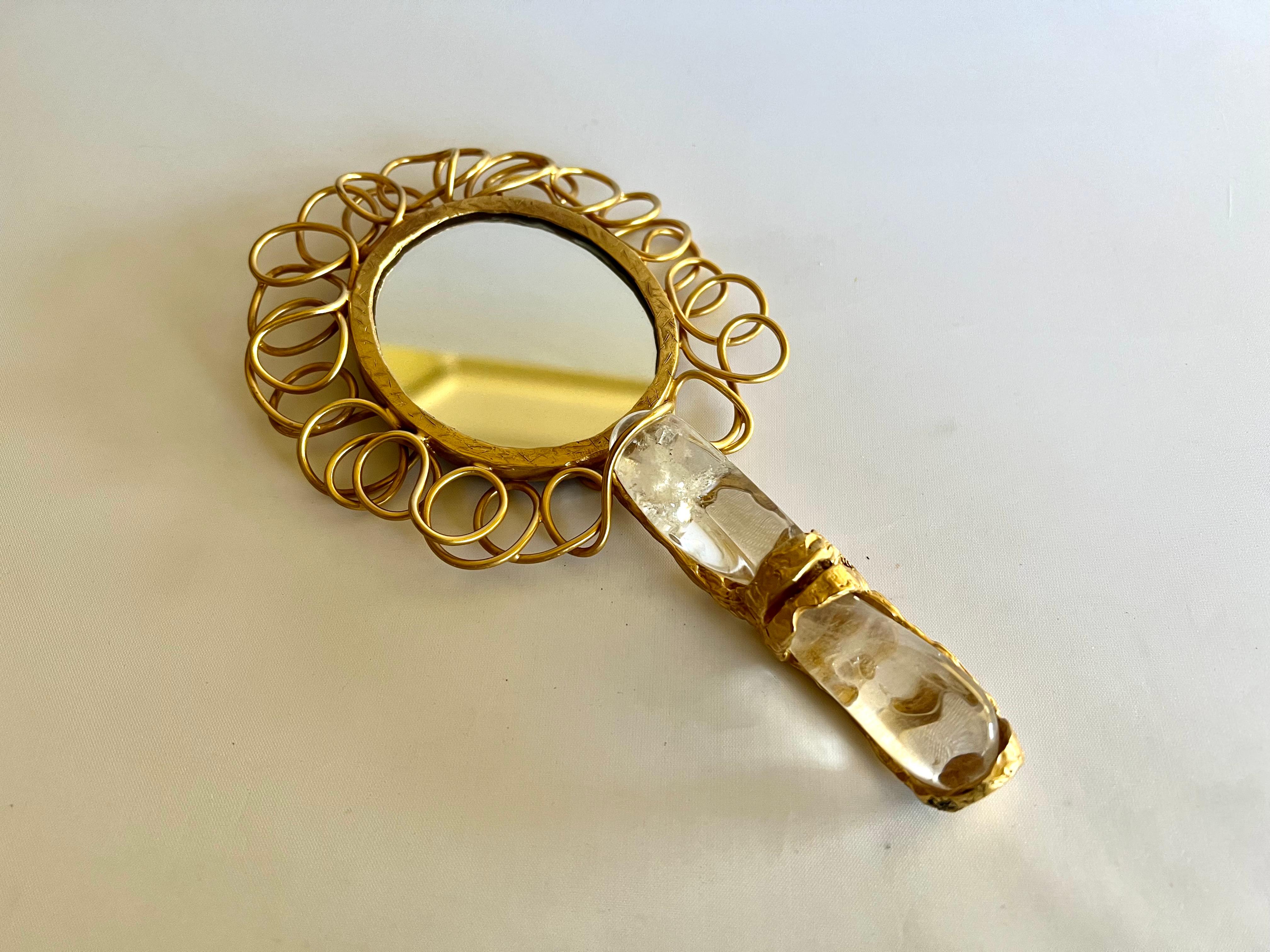 Specchio decorativo ovale del XXI secolo realizzato in bronzo dorato e manico in cristallo di rocca, alla maniera della Maison Robert Goossens - prodotto a Parigi in Francia.