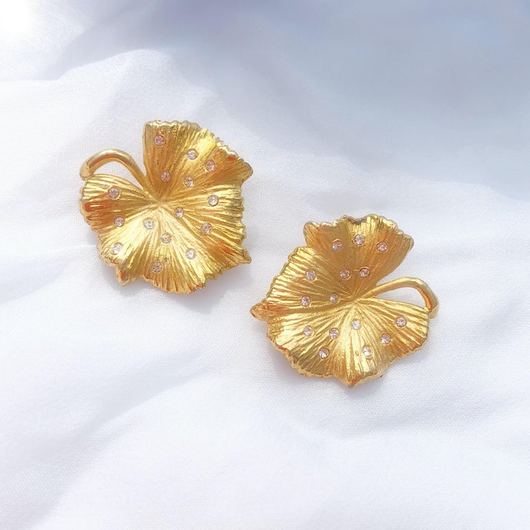 These rare, shiny statement earrings by Claudette, circa 1950s, are a great way to add a touch of sparkle to your look!  Two gold-plated leaves are studded with sparkling crystals in these gorgeous clip-on earrings. A wonderful addition to your