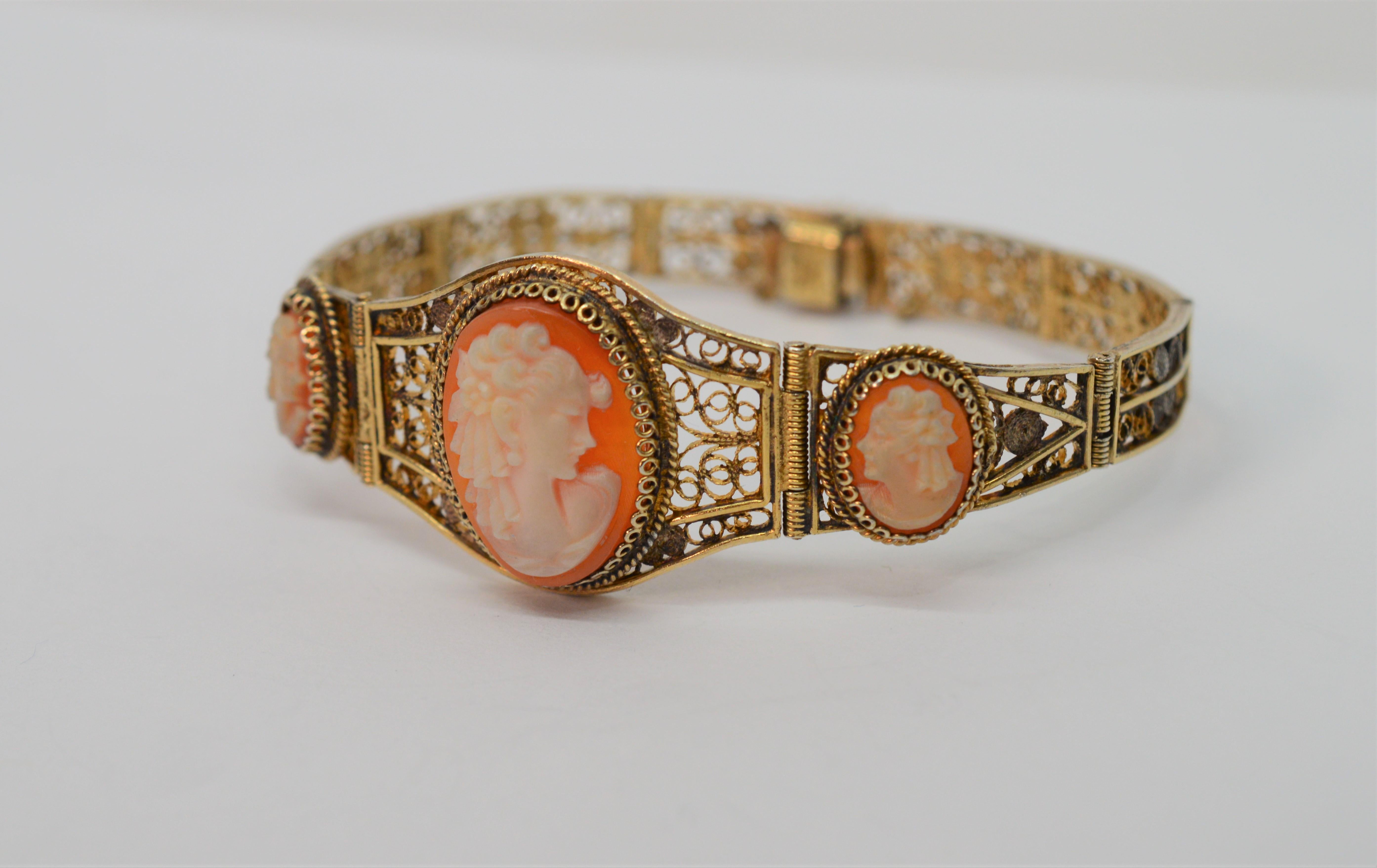 With notable artistry, nine fine filigree links made of gilded silver graduate forward to host three Victorian style carved shell cameos on this unique bracelet. The silhouettes depict a noblewoman with her ladies in waiting are featured with an