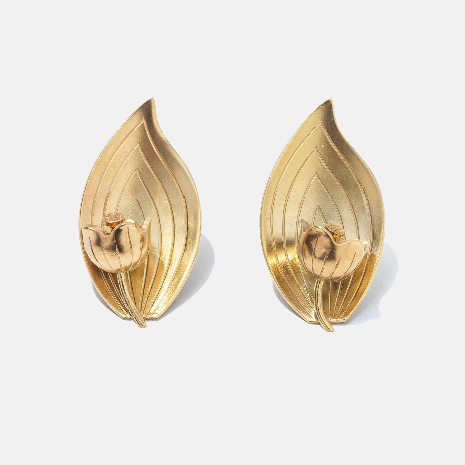 These gilded silver earrings showcase an elegant leaf and tulip design with a detailed, textured finish, offering an organic and refined aesthetic. The center of each leaf cradles a delicate tulip in bloom, adding a touch of floral elegance. They